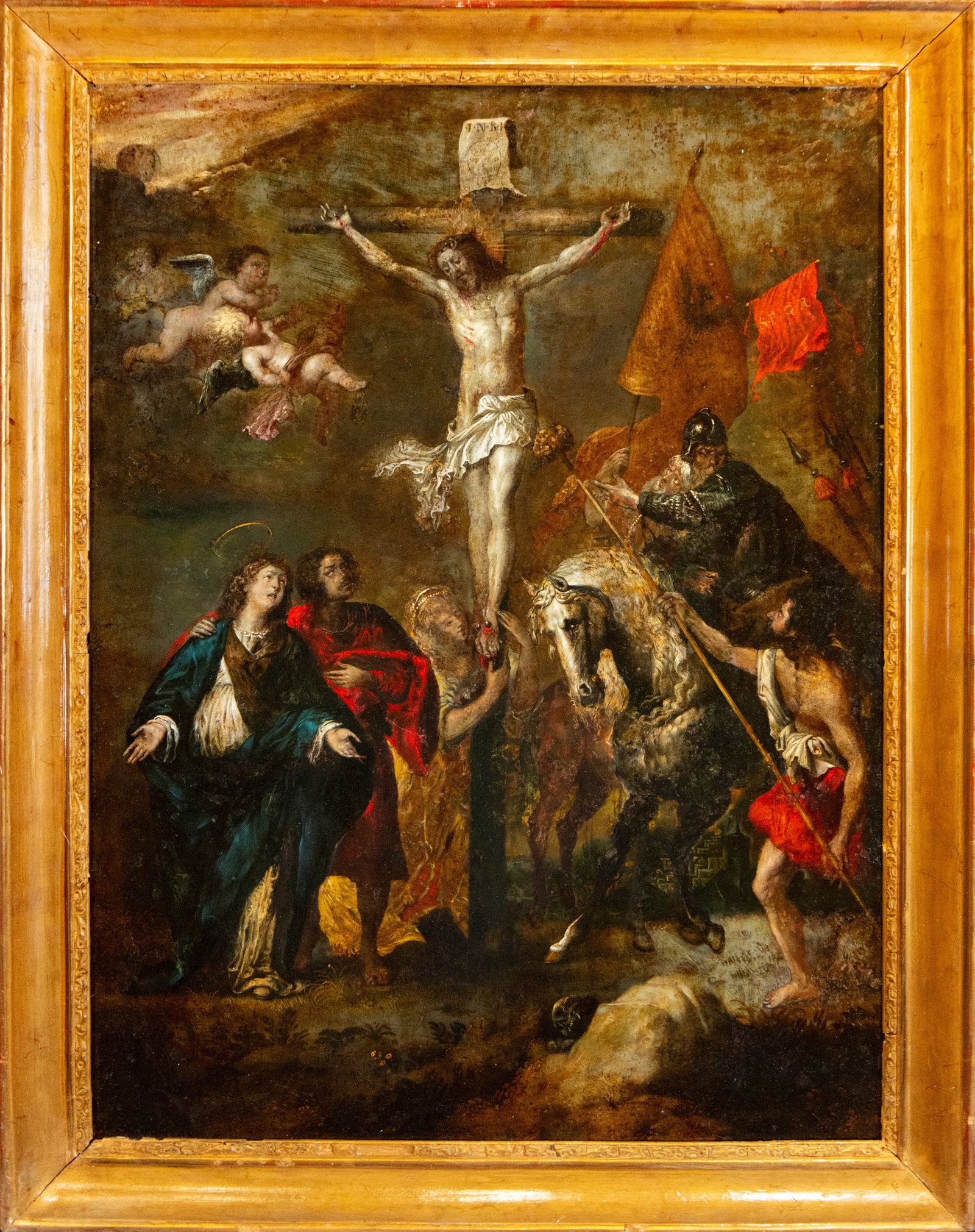 Workshop/Style of Anton van Dyck, circa 1630 – Flemish School – 17th Century: Oil on canvas. Religious composition centered on Christ crucified, accompanied in the lower section by the Virgin Mary and Saint John the Evangelist, while several soldiers and horsemen are grouped ar