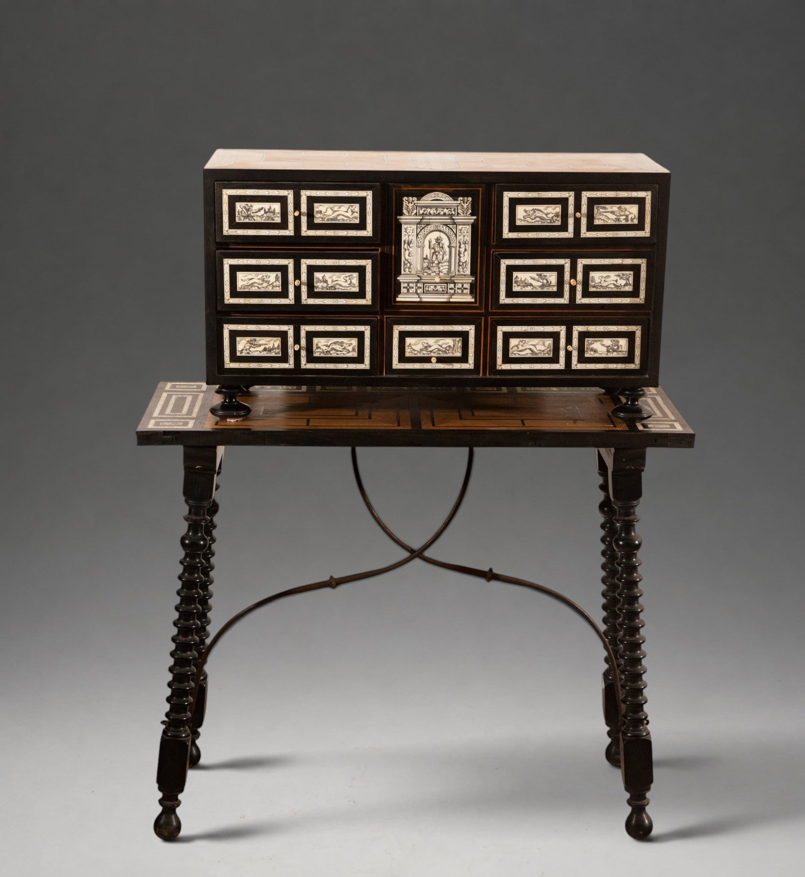Elegant 18th-century Hispano-Flemish Cabinet: A bargueño, or tabletop cabinet, on a freestanding base, made of dark wood and organized with several drawers and a central compartment of architectural design. The drawer fronts feature light-colore