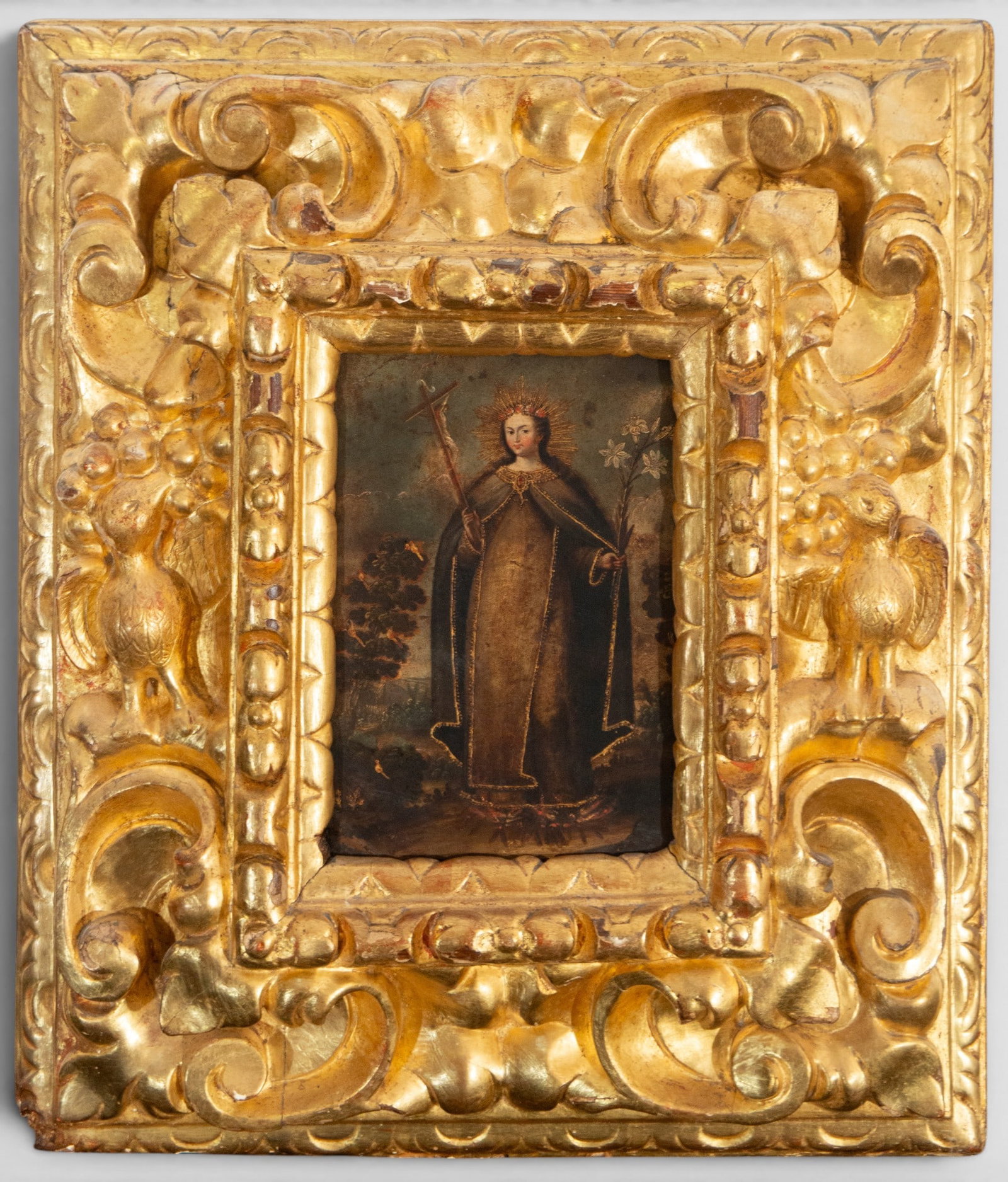Saint Rose of Lima, Patron Saint of Peru – School of Cuzco – 18th century: Oil on canvas. Depiction of a standing saint, dressed in a Carmelite habit with a radiant halo, holding a crucifix and a flowering staff adorned with lilies. The figure is positioned frontally against