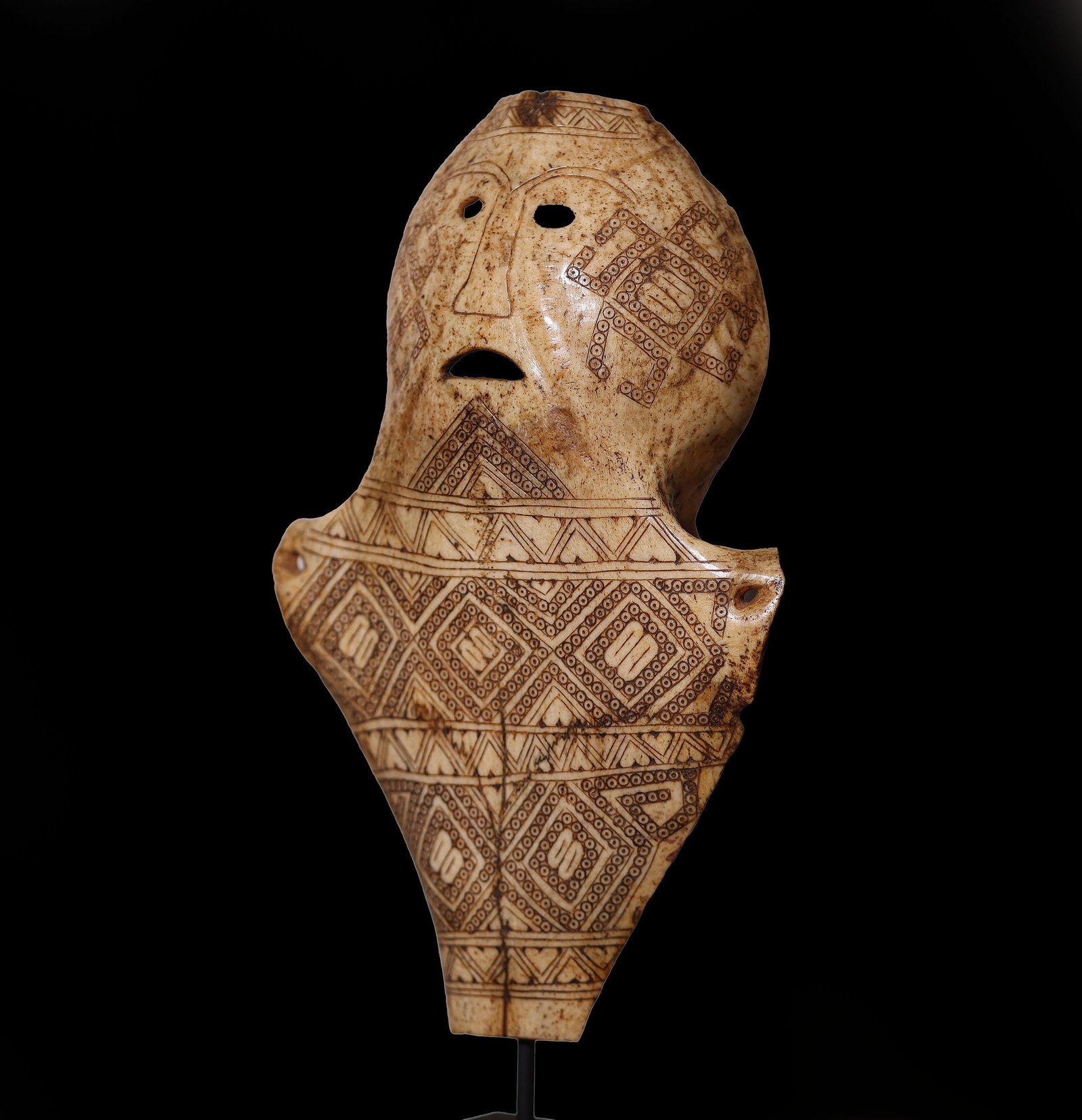 Exceptional Carved Bone Timor Oceania 19th Century - Asian Art: 21.5 x 13.5 x 4 cm. Indonesia, 19th-early 20th century. Carved from the top of an ox skull, the mask depicts a human face with a somber expression marked by wide-set eyes, a broad nose, and a turned-u