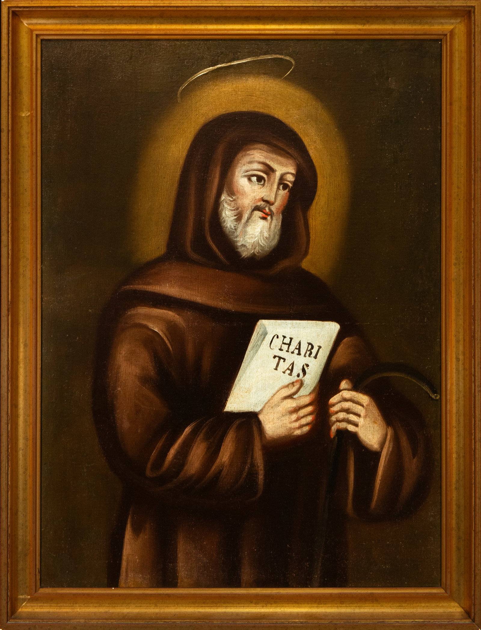 Saint Francis of Paula. Spanish School. 19th Century: Oil on canvas. This moving devotional image depicts an elderly saint with a white beard, a golden halo, and a brown tunic, holding a book inscribed with the word "Charitas, " a symbol of the virtue of