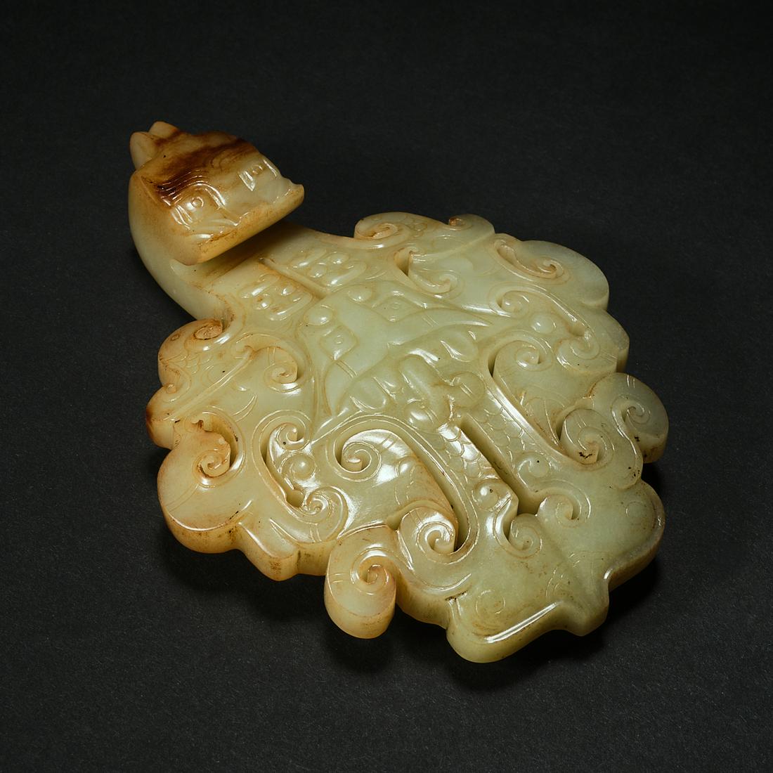 A yellow and russet jade 'phoenix' belt hook,height 11cm,length 8cm: Height cm ,Length cm ,Weight 135g .For size details ,please refer to the marks on our pictures.