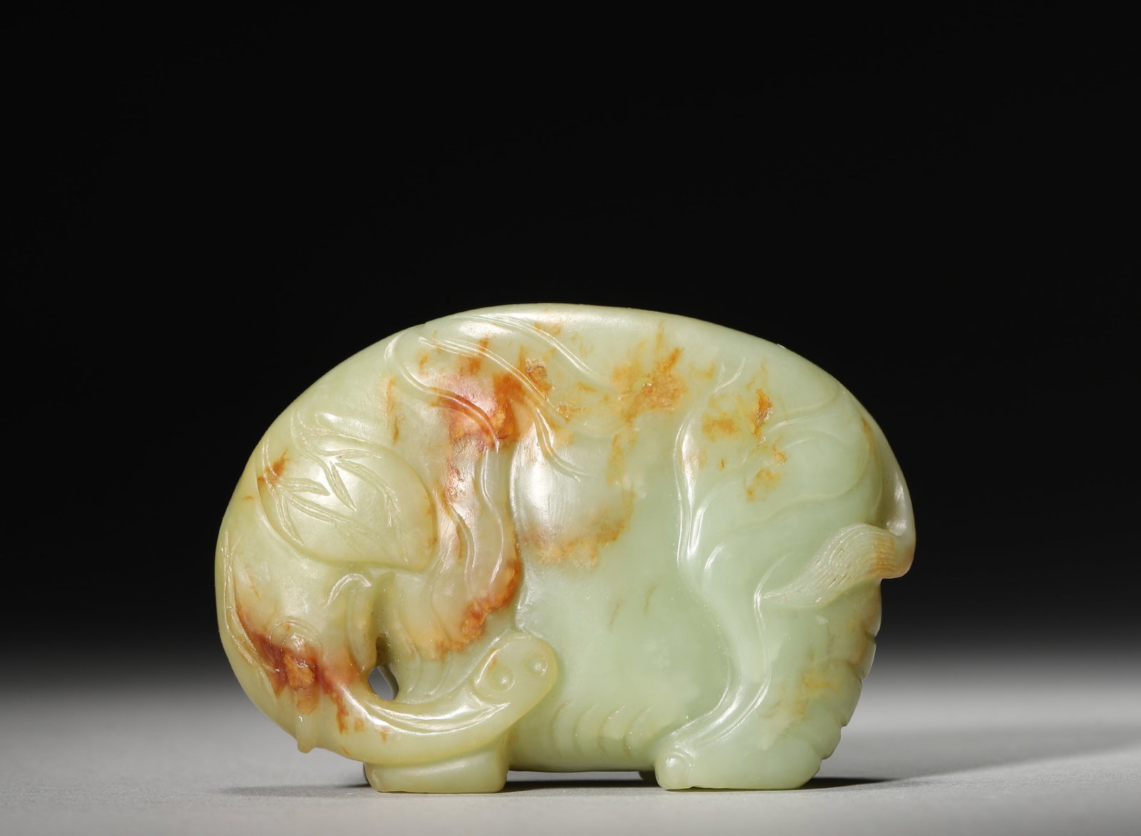 Qing Dynasty Celadon White Jade Carved Elephant (with Natural Skin): L: 7cm (2.76in), W: 2.2cm (0.87in), H: 4.8cm (1.89in)A finely carved Qing Dynasty celadon white jade elephant, with jade texture and natural skin. The vivid, succinctly-lined form embodies the Qing ja