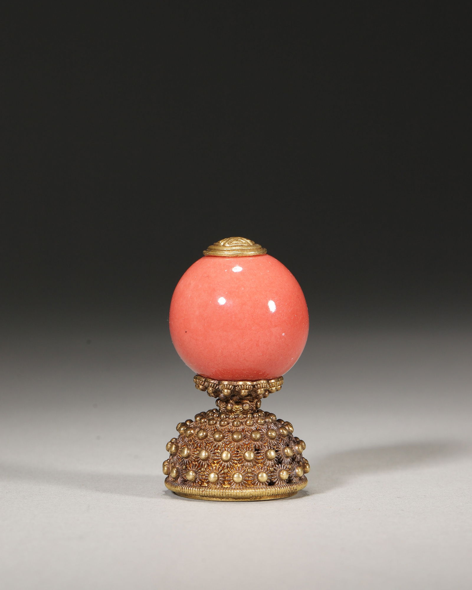 Qing qianlong period, coral-imitation glass gilt hat finial: Imperial hat finial, qianlong reign (1736-1795): coral-imitated glass with gilt filigree base, “double happiness” motif. A rare surviving example of qing official attire artifacts;