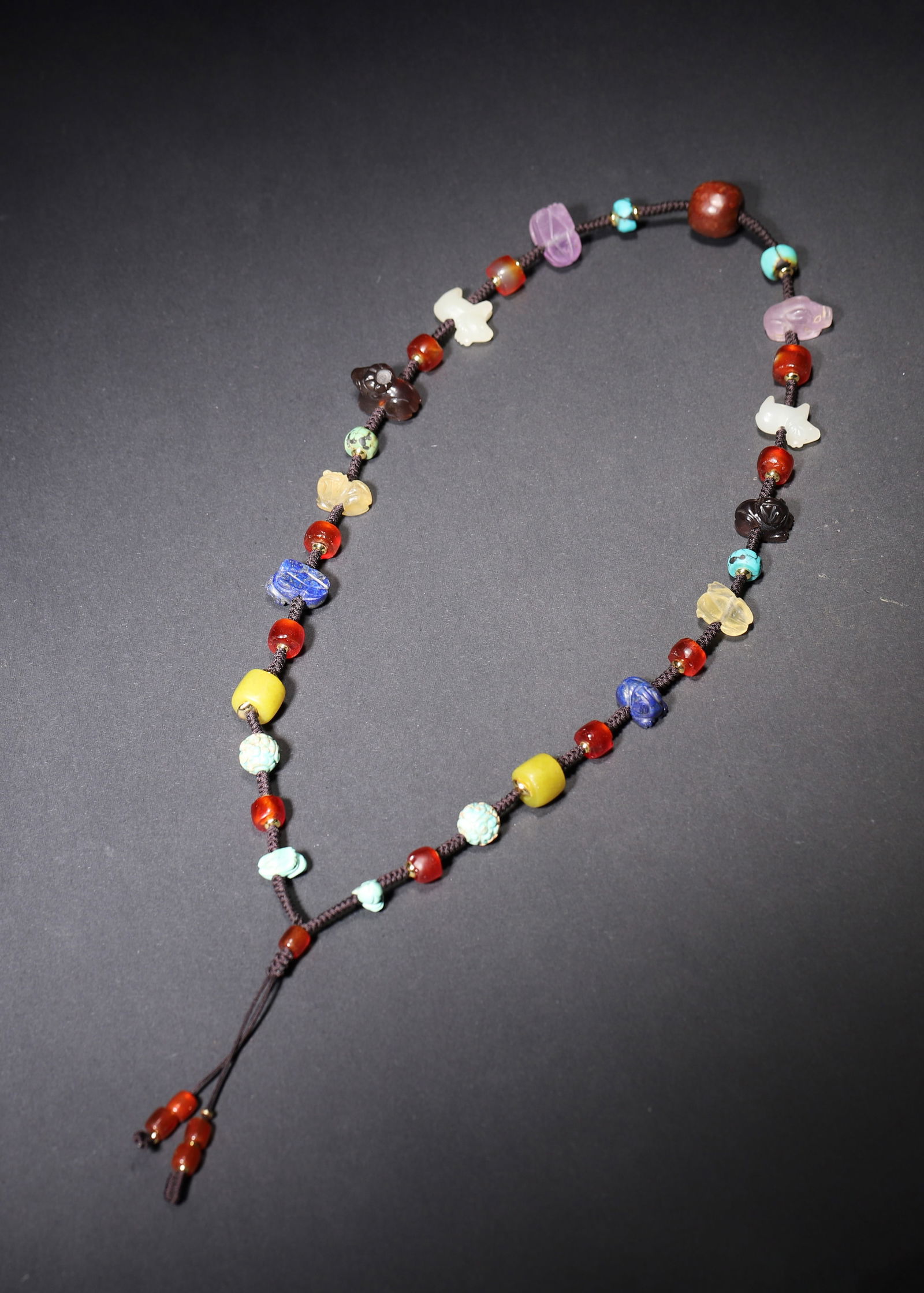 Western zhou dynasty multi-gem beaded necklace: This Western zhou dynasty necklace is strung with agate, lapis lazuli, crystal, jade, and turquoise. Its freeform beads and carved jade elements reflect the era's "treasure-gathering" aesthetic,