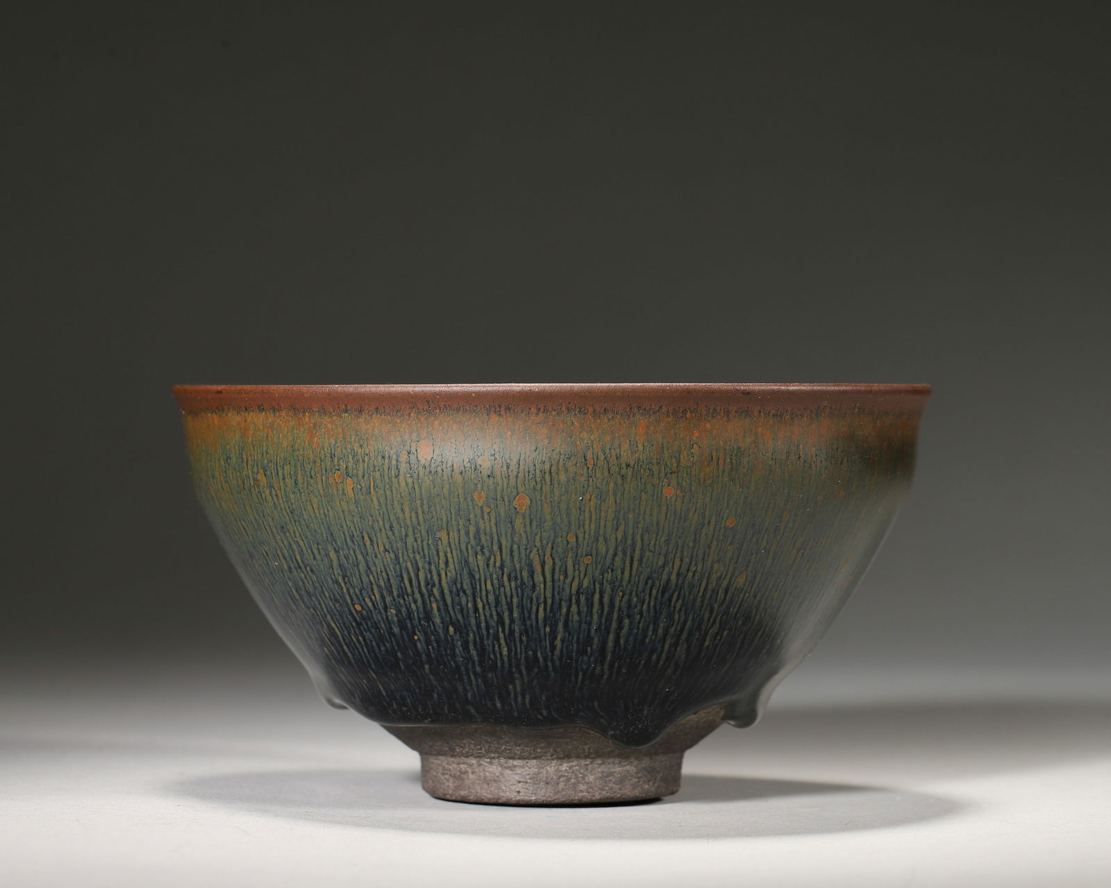 Song dynasty jian kiln "gong yu" marked hare's fur bowl: A rare imperial song jian bowl with "gong yu" mark: dynamic hare's fur glaze, blue-black fusion. A court tea-competition vessel merging kiln craft & imperial status—a pinnacle of song black-glazed