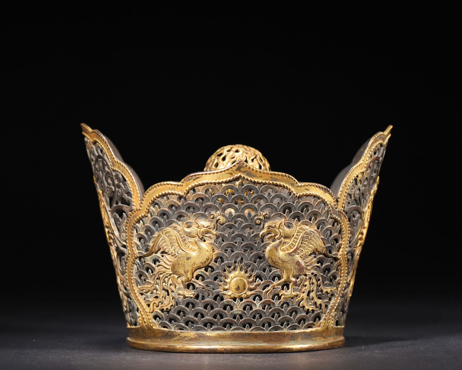 Song to ming dynasty, gilt-bronze openwork crown with phoenix motifs: A fine gilt-bronze crown from the song to ming dynasty, featuring a five-lobed floral form, openwork scroll patterns, and high-relief phoenix motifs. It reflects the social hierarchy and aesthetic