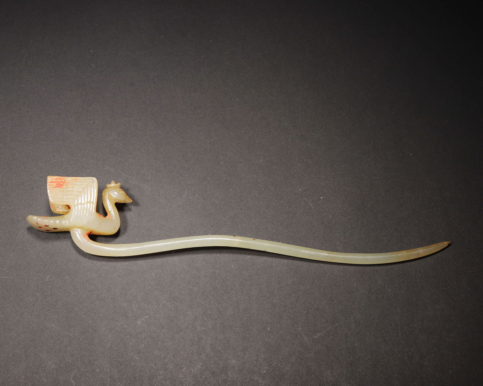 Han dynasty, white jade hairpin with phoenix finial: An exceptional han dynasty with jade hairpin, featuring a finely carved phoenix finial with detailed feather patterns. The slender pin retains traces of cinnabar, reflecting the noble status and ritua