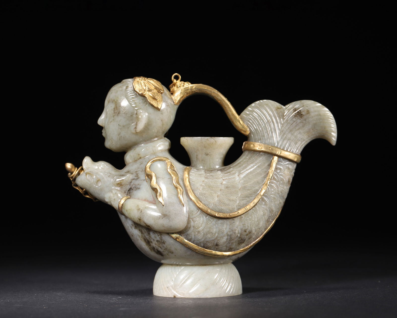 A hetian jade gilt-mounted "makara" ewer, liao dynasty: This ewer, a masterpiece of the liao dynasty, is carved from hetian jade with gilt mounting, depicting a 'makara' with human head and fish body. Exquisitely crafted with typical motif, it embodies exc