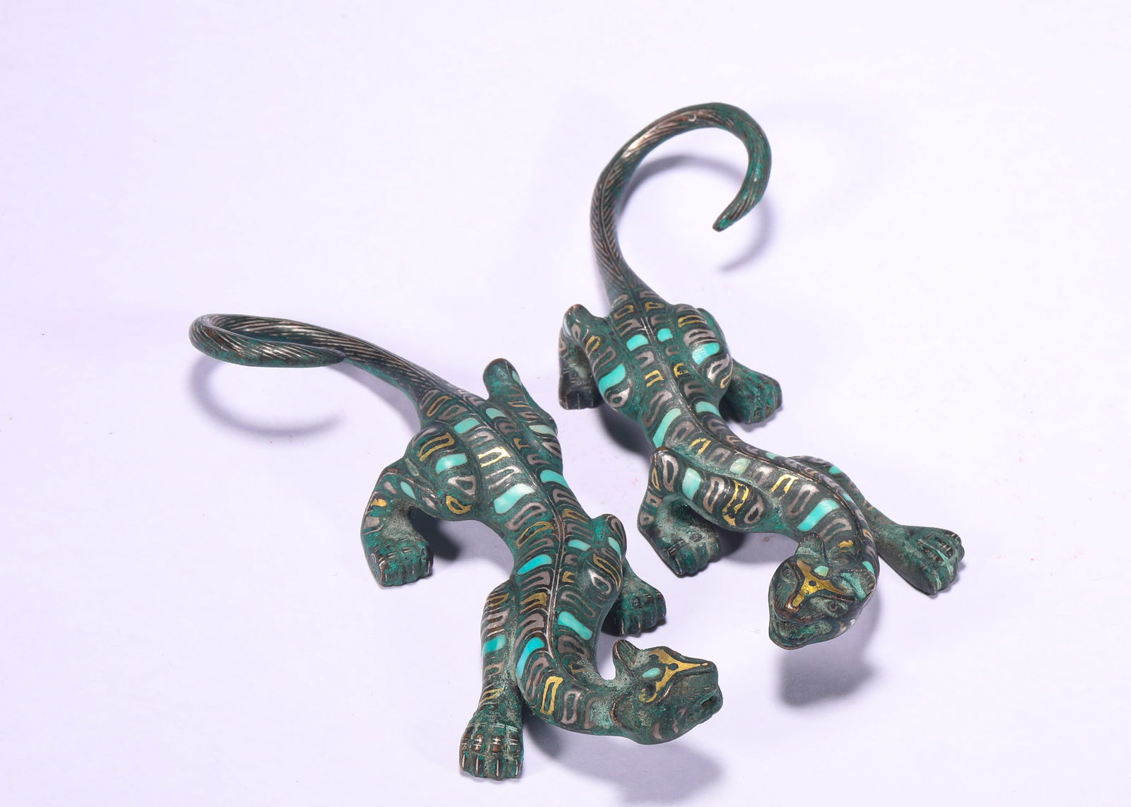 BRONZE INLAID WITH GOLD AND SILVER INLAID WITH TURQUOISE AUSPICIOUS BEAST ORNAMENTS FROM THE WARRING: H:1.5cmW:12.5cmWeight:310g This is a pair of bronze mythical beast ornaments inlaid with gold, silver and turquoise from the Warring States Period, a decorative piece for the aristocracy of that time