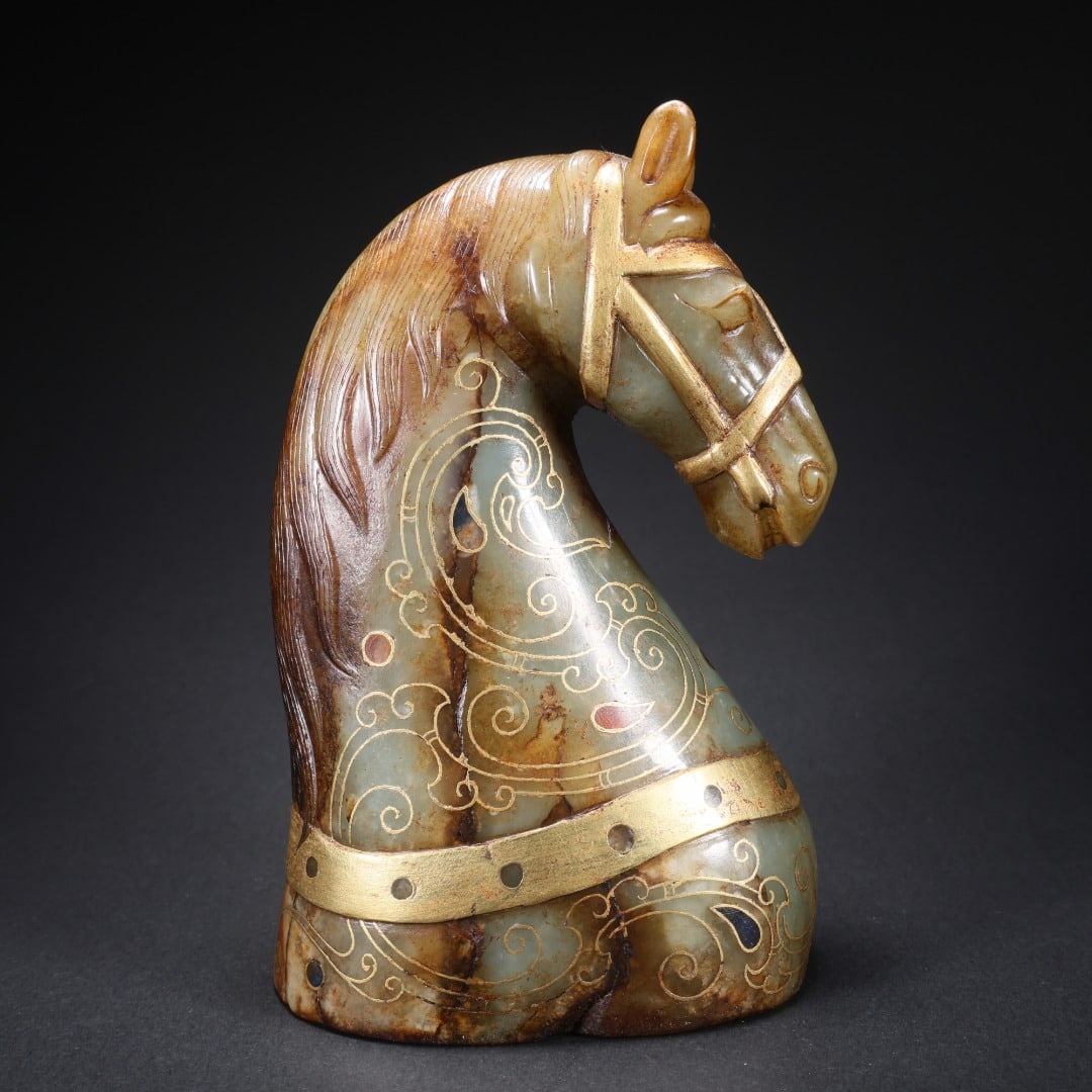 TANG DYNASTY HETIAN JADE HORSE HEAD INLAID WITH GOLD AND GEMSTONES: L:8.5cmW:5.6cm?H:13.4cm?Weight:827g This is a Hotan Jade inlaid with gold inlaid BMW head decoration of the Han Dynasty, which is a luxury display of the Han Dynasty aristocratic class. It is a typica