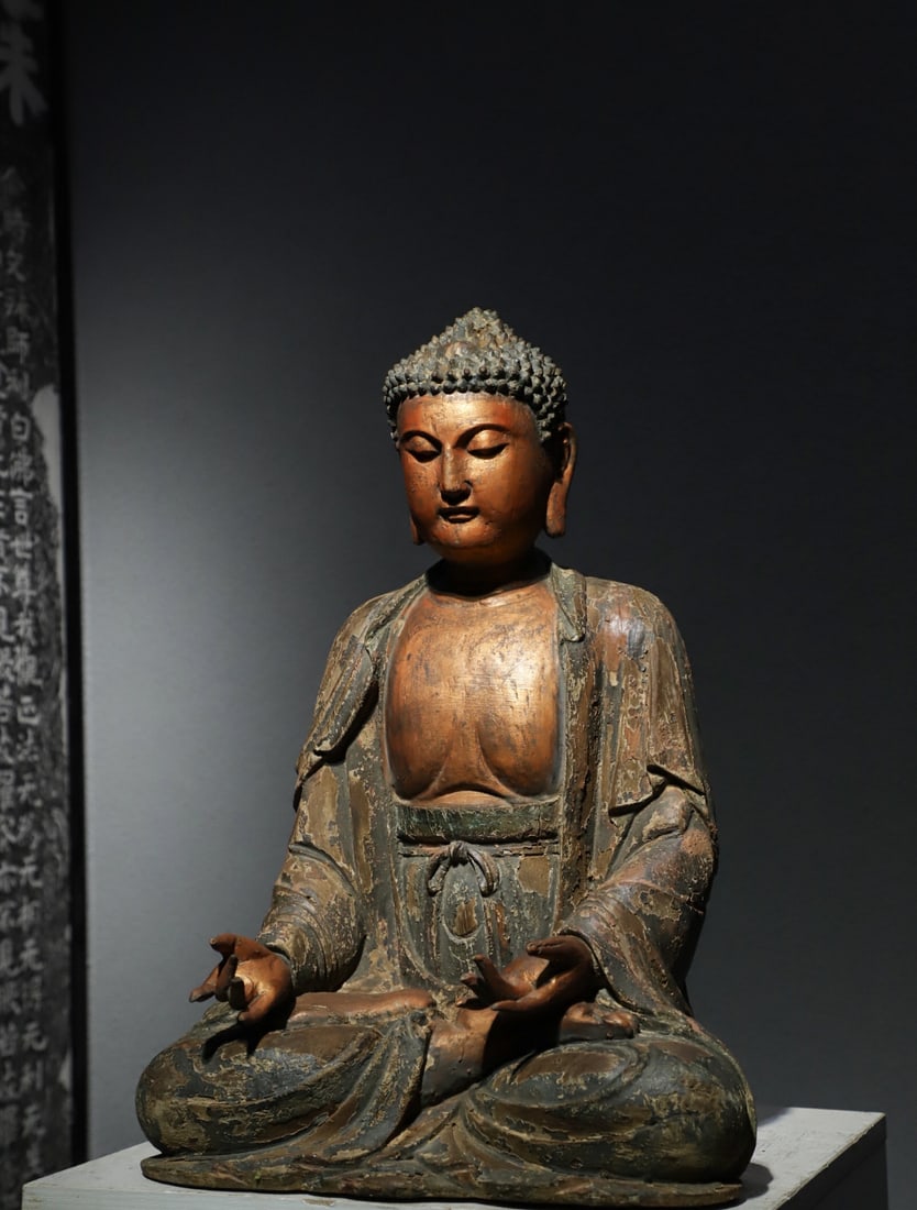 SONG DYNASTY CAMPHOR WOOD, SAKYAMUNI BUDDHA STATUE: H:52cmL:35cmW:28cmThis is a seated statue of Sakyamuni Buddha carved and painted in wood from the Song Dynasty, which is a typical representative of Buddhist statues in the Song Dynasty. This statue e