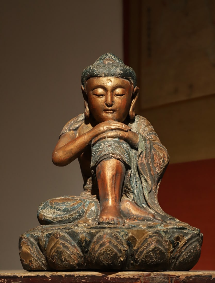 SONG DYNASTY, WOODCARVING LACQUER GOLD THINKING BUDDHA: H:35cmL:26cmW:17cmThis is a Song Dynasty wood sculpture painted thinking Bodhisattva sitting statue, is the ancient Chinese Buddhist statues in a very humanistic atmosphere of the classic subject.