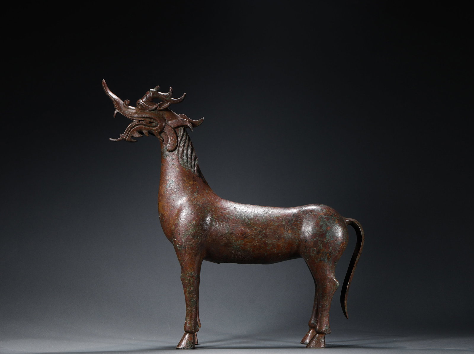 BRONZE AUSPICIOUS BEAST OF THE WARRING STATES PERIOD: H:34cmW:32cmWeight:3420g This is a bronze mythical beast ornament with a horse's head and a dragon's body (also known as a dragon horse) from the Han Dynasty, a ritual vessel that embodies both practi