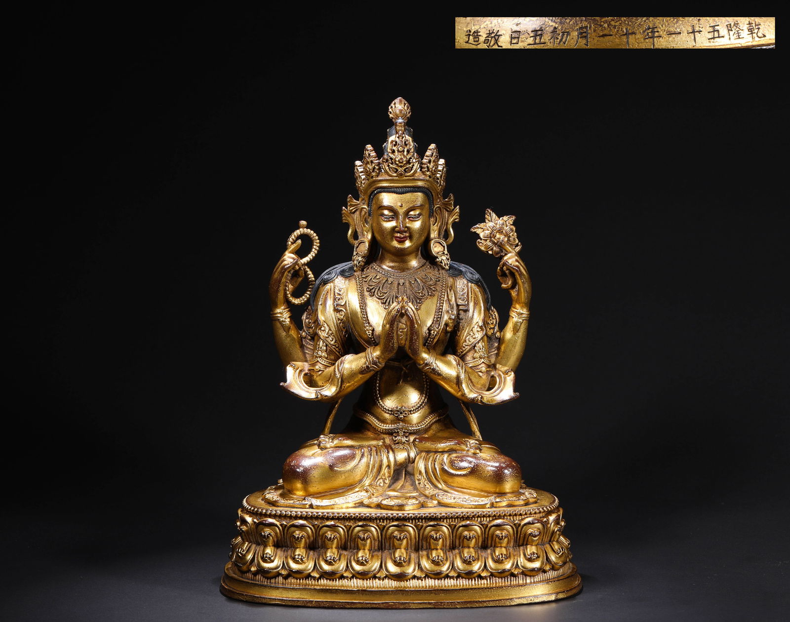 A GILDED BRONZE STATUE OF THE FOUR-ARMED GUANYIN BY EMPEROR QIANLONG OF THE QING DYNASTY: H:24cmW:17cmWeight:2720g This is a gilded bronze seated statue of Four-Armed Avalokite?vara, imperial court-made in the 51st year of the Qianlong reign (1786) of the Qing Dynasty, and an exquisite exa