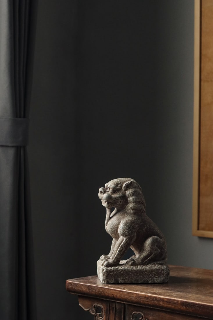 CARVED BLUESTONE SEATED GUARDIAN LION, TANG DYNASTY: 9.45" x 4.72" x 6.3" inches (24cm x 12cm x 16cm)Squatting posture, head raised, gazing far ahead with fierce eyes, mouth open revealing teeth.Strong limbs, full of majestic and domineering aura.Ideal