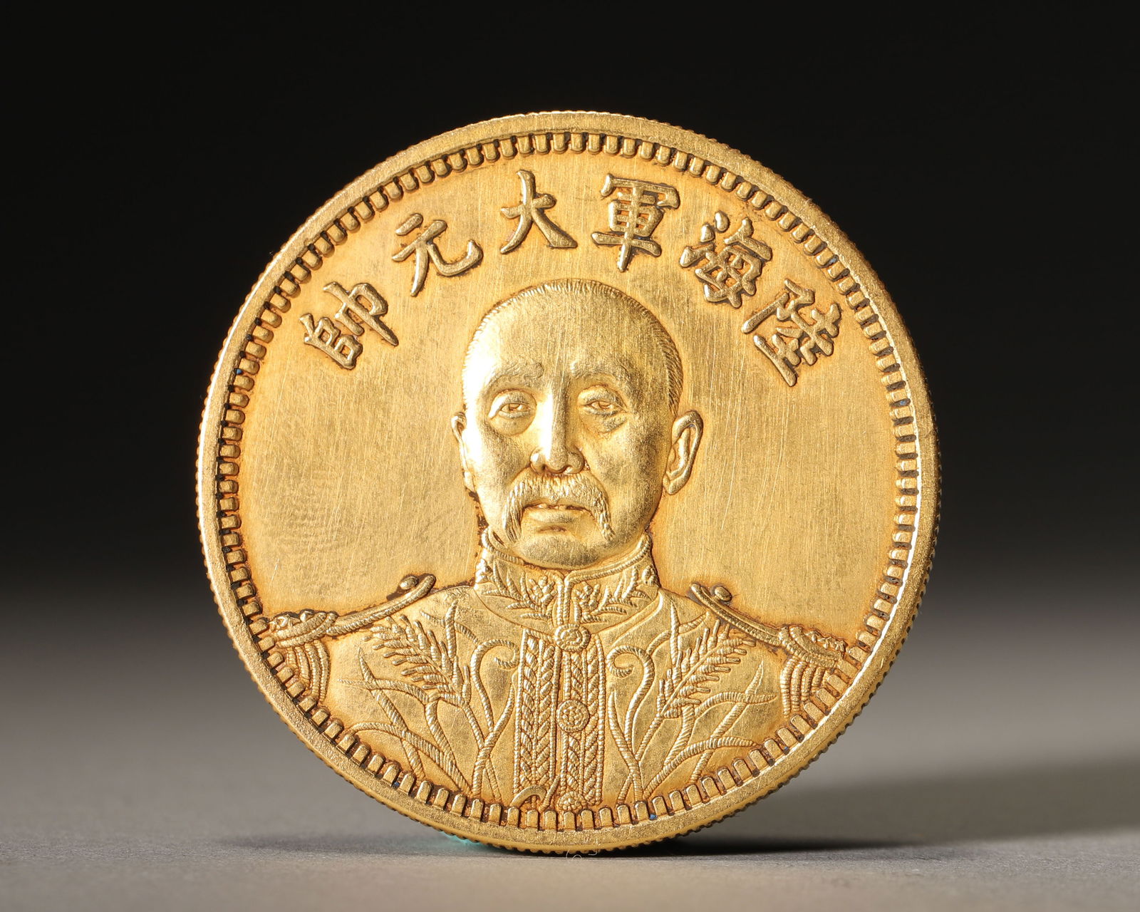 A FINE GOLD 'GRAND MARSHAL' COMMEMORATIVE DOLLAR: Diameter: 1.57" (4cm) | 0.08 lbs (37g)A fine gold 'Grand Marshal' commemorative dollar, dated to the 15th year of the Republic of China (1926), depicting Zhang Zuolin on the obverse and a radiant sun