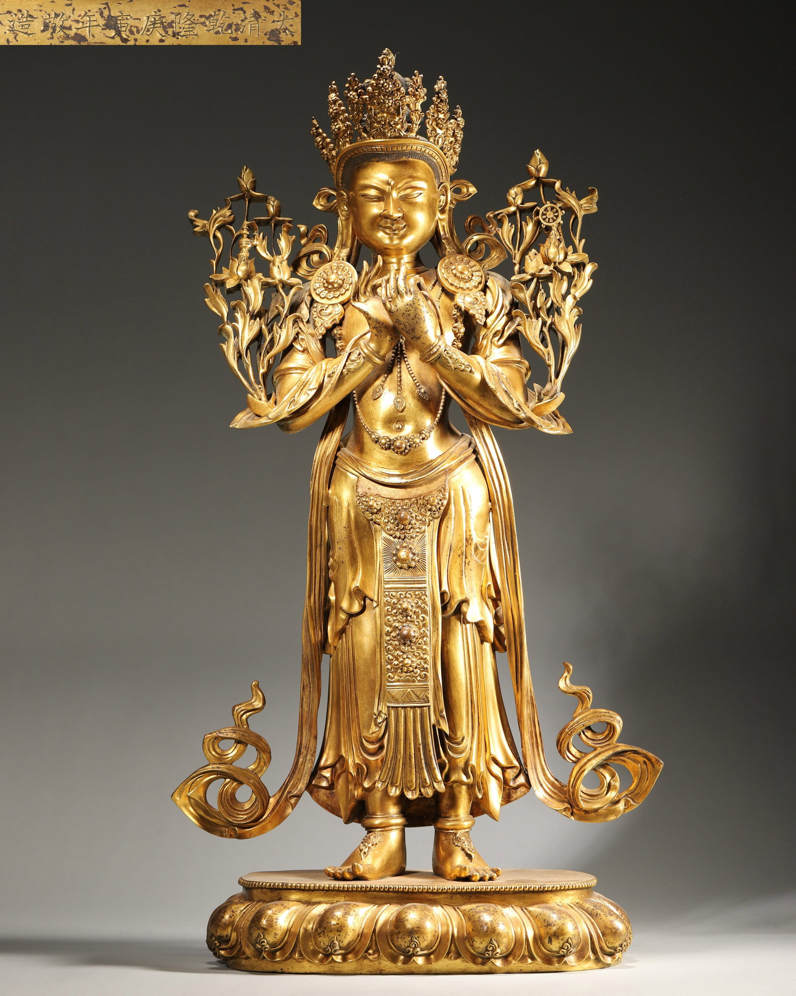 A QIANLONG PERIOD (1736-1795) IMPERIAL COURT-MADE GILT-BRONZE STANDING FIGURE OF AVALOKITESHVARA: 13.0" x 5.12" x 24.41" (33cm x 13cm x 62cm) | 21.72 lbs (9850g)A magnificent imperial gilt-bronze standing figure of Padmapani, dated to the Qianlong reign (1770), with hands in dharmachakra mudra, st