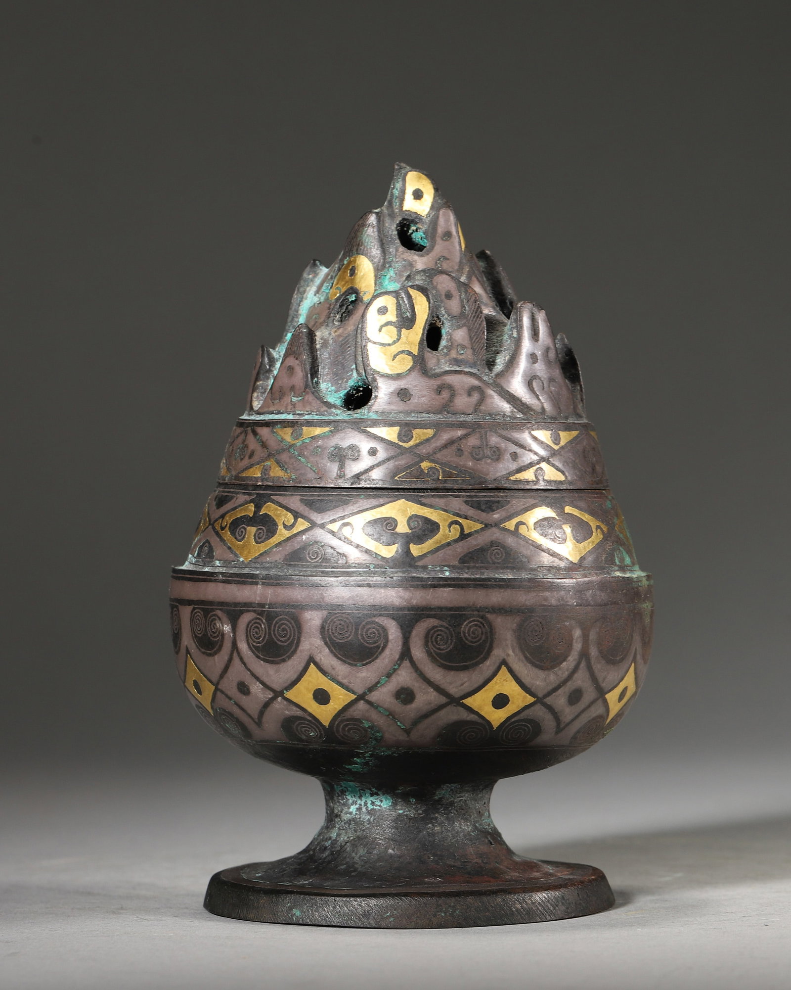 AN IMPORTANT ARCHAIC BRONZE BOSHAN INCENSE BURNER WITH GOLD AND SILVER INLAY, EARLY WESTERN HAN: D:8cm (3.15in) H:12cm (4.72in) WT:588g (1.30lb)A fine archaic bronze Boshan incense burner, Early Western Han dynasty, with gold and silver inlaid geometric patterns, mountain-form cover, of excellent