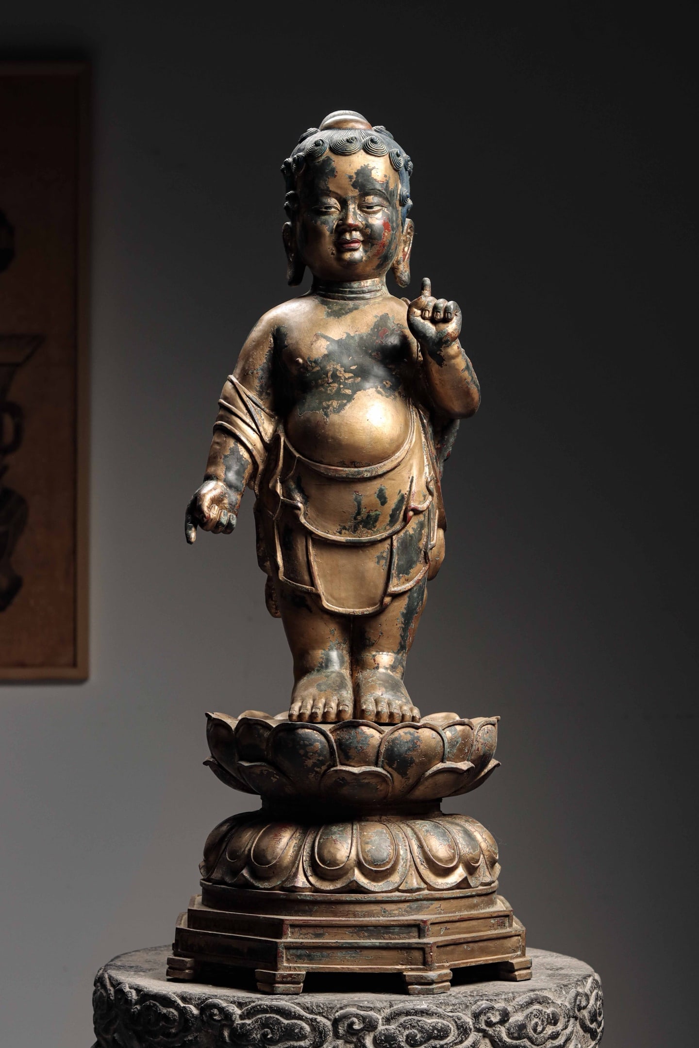 GILT-BRONZE STANDING FIGURE OF INFANT BUDDHA, MING DYNASTY: Height: 31.89" inches (81cm), Base Diameter: 13.78" inches (35cm) | Weight: 36.05 lbs (16350.0 g)With a kind and dignified face, broad forehead, lowered eyelids and gentle gaze, he has full lips and l