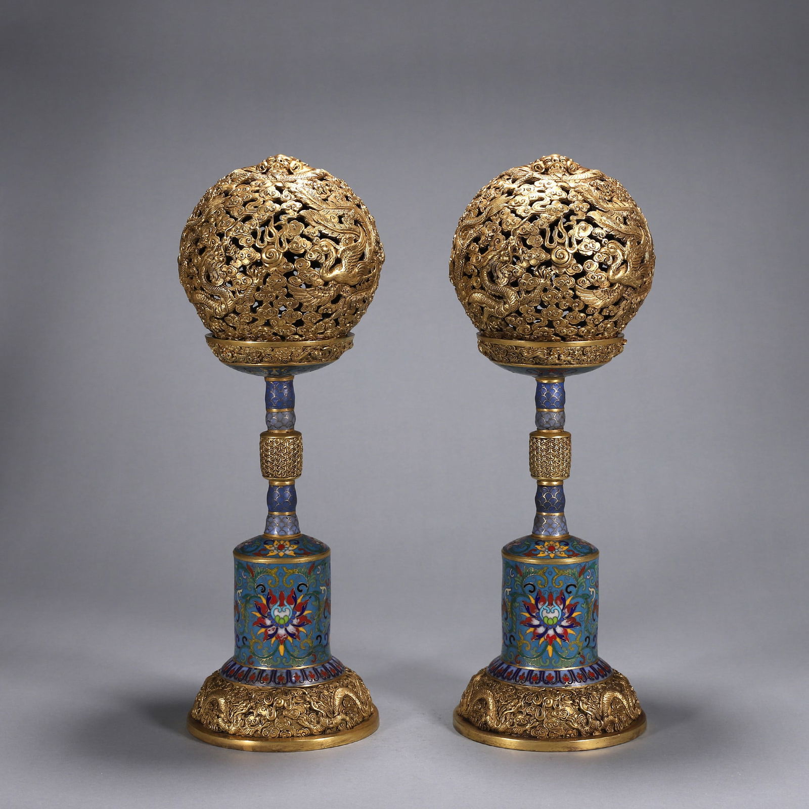 A PAIR OF IMPORTANT GILT-BRONZE AND CLOISONNÉ ENAMEL 'DRAGON AND PHOENIX' INCENSE HOLDERS, QIANLONG: W:13cm (5.12 in) H:39cm WT:6.15kgA fine pair of gilt-bronze and cloisonné enamel incense holders, Qianlong period, with openwork dragon and phoenix spheres, of imperial quality.