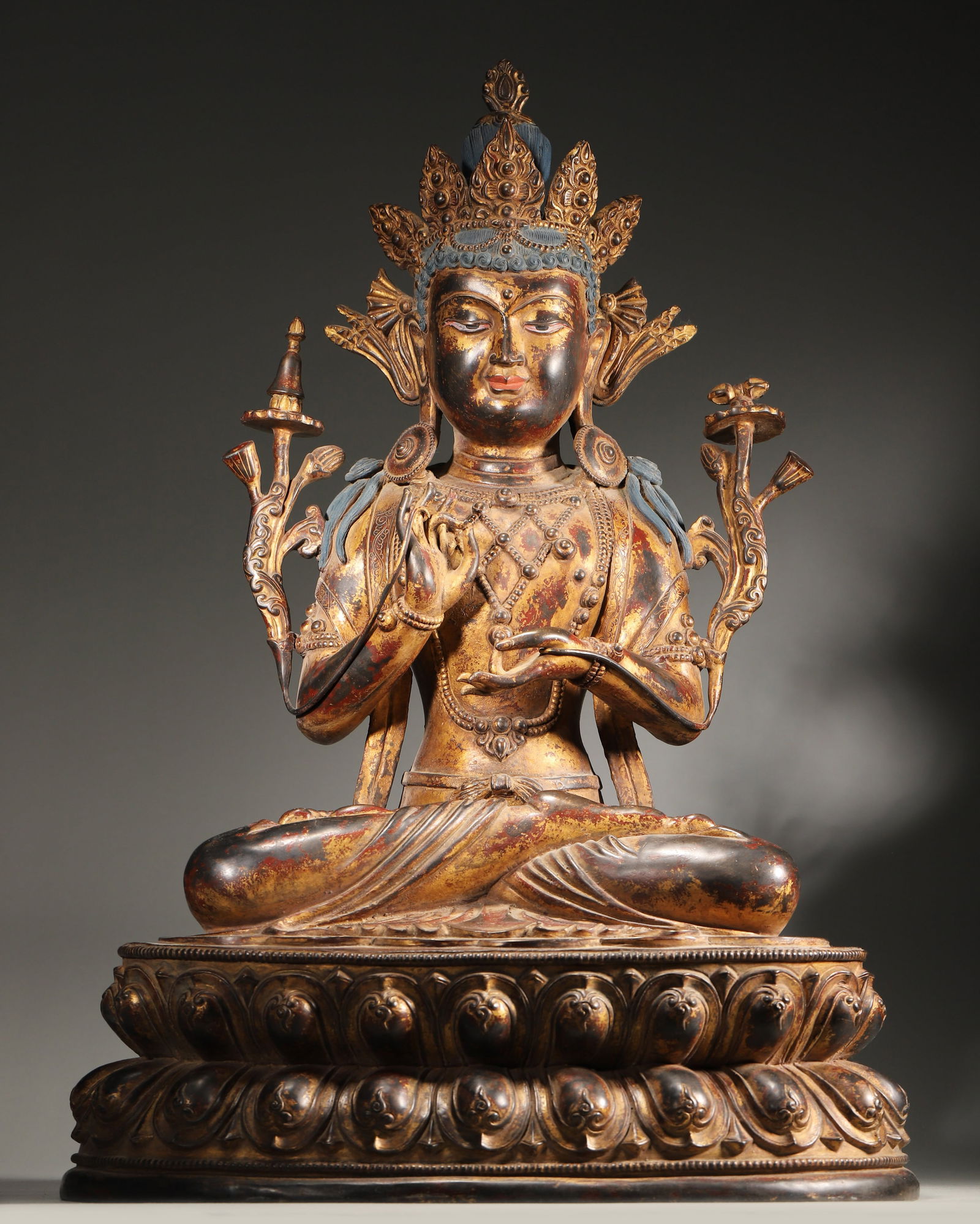 A FINE GILT-LACQUERED BRONZE FIGURE OF MANJUSHRI, QING DYNASTY: 15.35" x 11.81" x 23.23" (39cm x 30cm x 59cm) | 57.54 lbs (26100g)A fine gilt-lacquered bronze figure of Manjushri, Qing dynasty, seated in dharmachakra mudra, holding a sutra and stupa, on a double l