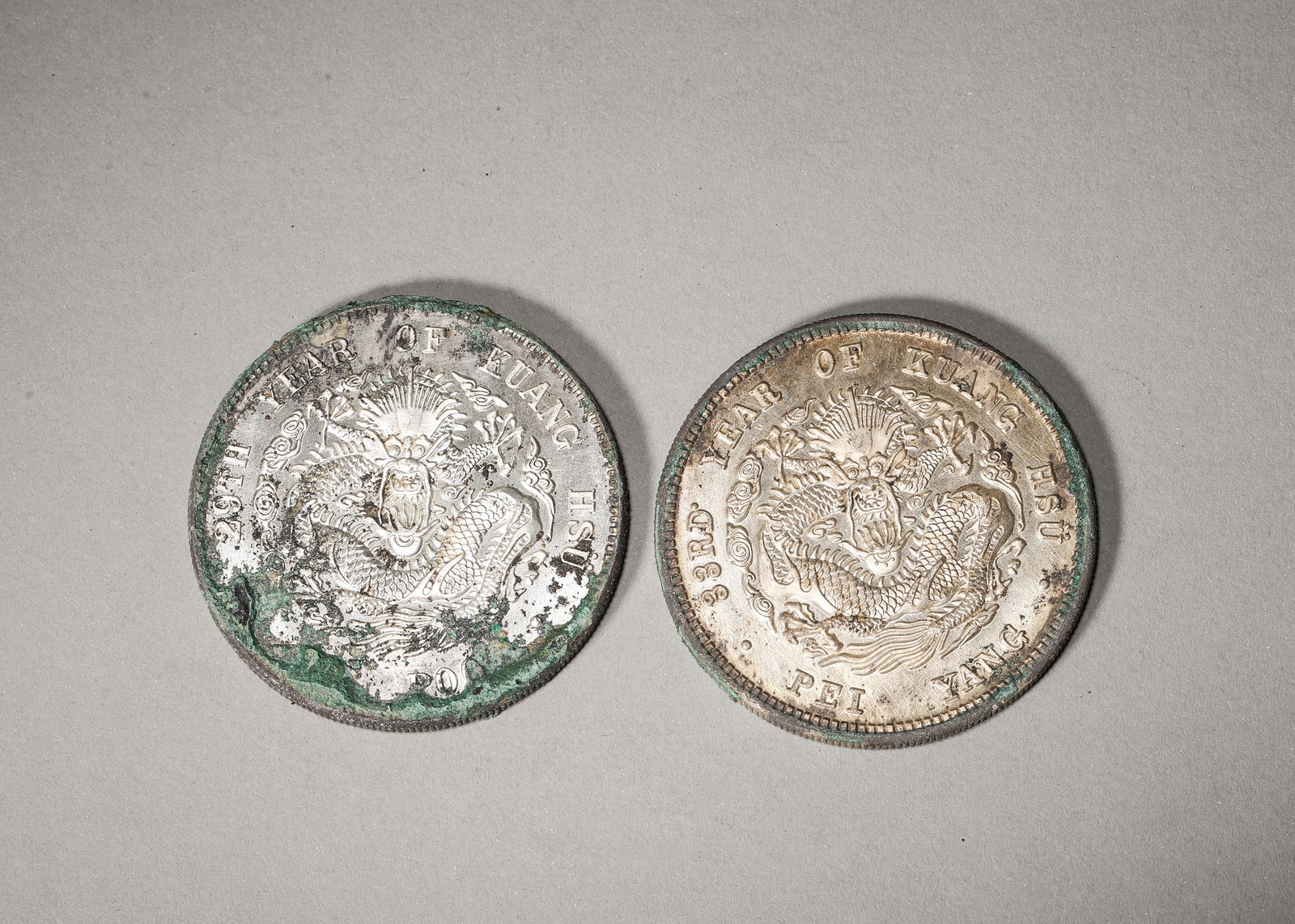 PAIR OF PEI YANG KUANG HSU SILVER DOLLARS: 1.73 in (4.4 cm) | 0.16 lb (74 g)A pair of rare silver dollars, one with rich patina and one with bright silver, featuring Kuang Hsu inscriptions on obverse, majestic dragon and English inscriptions o