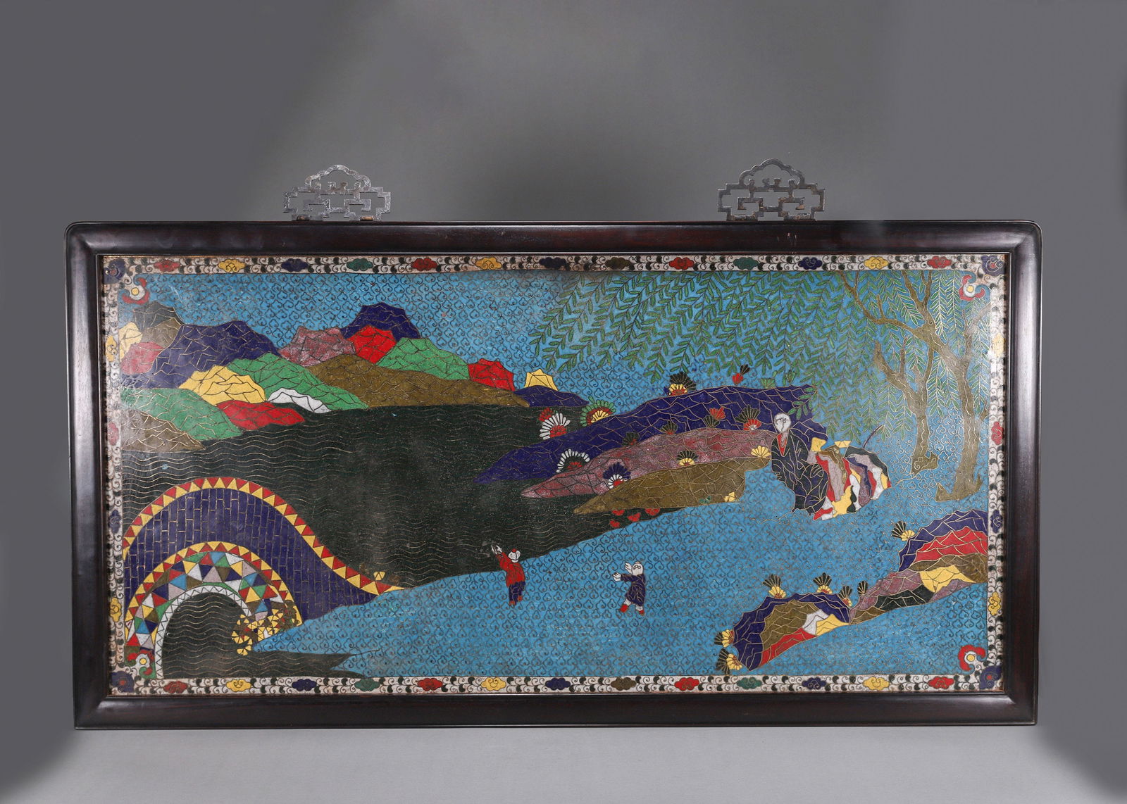 AN IMPORTANT CLOISONNÉ ENAMEL 'FISHING PLEASURE' HANGING SCREEN, QING DYNASTY: L:85cm (33.46 in) W:44.5cm (17.52 in)A fine cloisonné enamel hanging screen, Qing dynasty, depicting a riverside fishing scene, symbolizing prosperity and contentment.