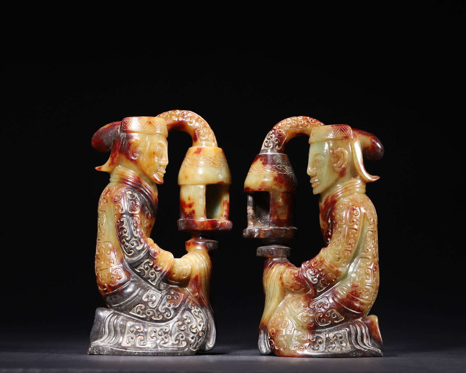 HAN DYNASTY, A PAIR OF HETIAN JADE KNEELING FIGURE LAMP ORNAMENTS WITH ANCIENT CALCIFICATION: 3.54" x 2.76" x 6.69" inches (9.0 cm x 7.0 cm x 17.0 cm) | Weight: 6.0 lbs (2723.0 g)Carved from Hetian jade with gorgeous natural calcification, depicting vivid kneeding figures holding lamps. A rare