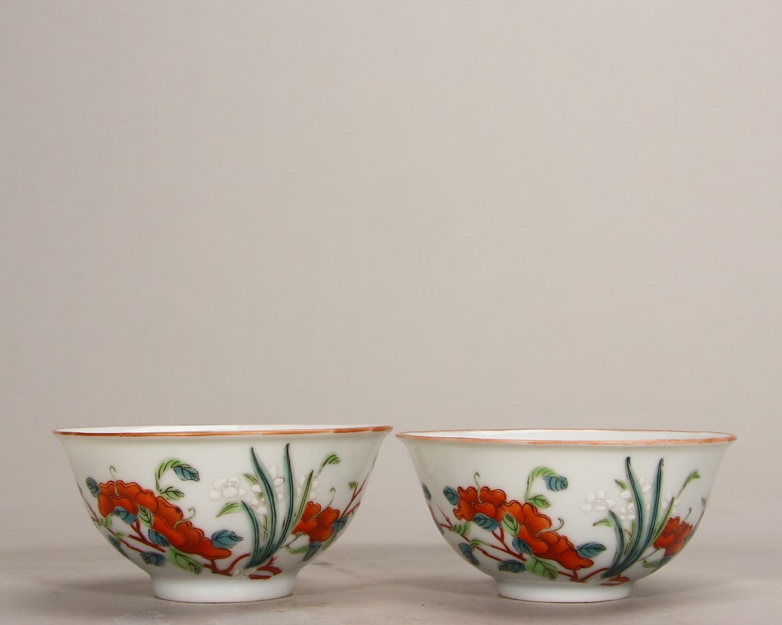 A FINE PAIR OF QING QIANLONG PERIOD FAMILLE ROSE FLORAL SMALL BOWLS: D3.58in x H1.77in (D9.1cm x H4.5cm)This delicate pair of imperial bowls is painted with vibrant famille rose sprays of flowers and orchids, with gilt rim accents. A rare Qianlong mark example, showcas