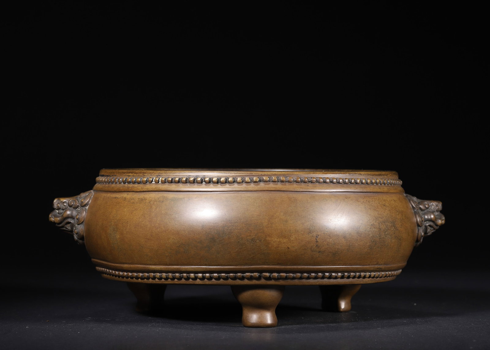 MING DYNASTY, CHONGZHEN PERIOD, A BRONZE TRIPOD CENSER WITH BEAST HANDLES, STUDDED DECORATION AND: 9.45" x 3.54" (24.0cm x 9.0cm) | 7.088lb (3215g)This refined Chongzhen-period bronze censer features beast-head handles, studded bands, and sturdy tripod feet. With a rich aged patina and precise 'Shi