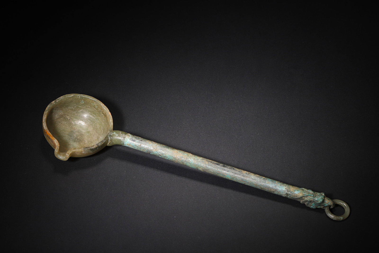 A FINE HAN DYNASTY GREEN JADE AND BRONZE LADLE WITH TURQUOISE INLAY AND DRAGON-HEAD HANDLE: 11.81in x 3.15in (30.0cm x 8.0cm), 0.459lb (208.0g)This Han Dynasty ladle features a green jade bowl inlaid with turquoise, paired with a bronze dragon-head handle. The harmonious combination of jade