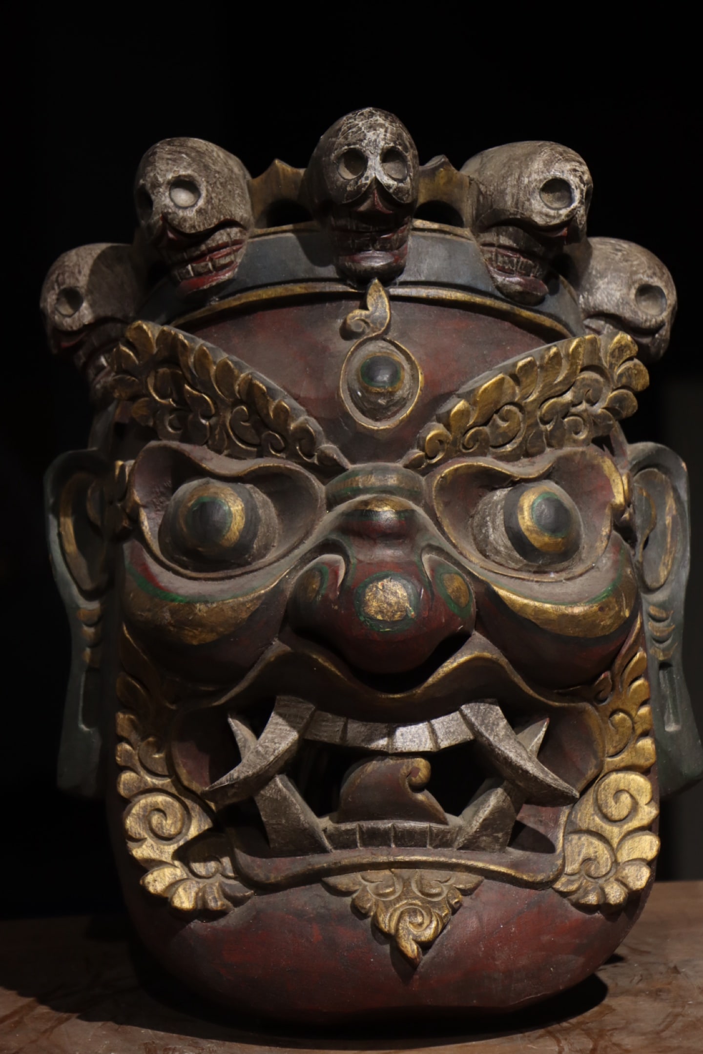 A CARVED AND GILDED WOODEN TUNKOU (GUARDIAN MASK) WITH FIVE SKULLS, QING DYNASTY, 18TH–19TH (1 of 9)
