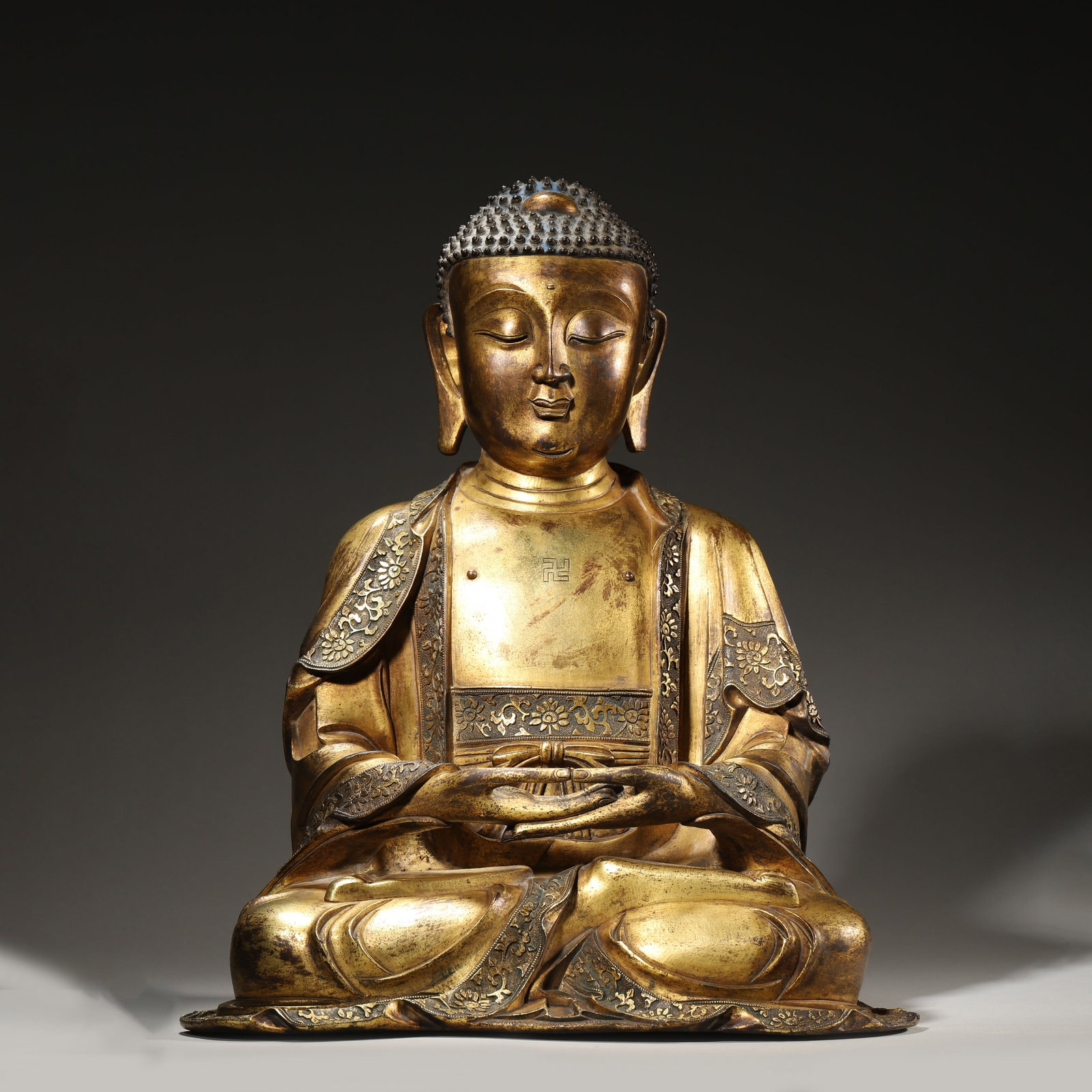 A GILT-BRONZE SEATED FIGURE OF SHAKYAMUNI BUDDHA, MING DYNASTY (1 of 14)