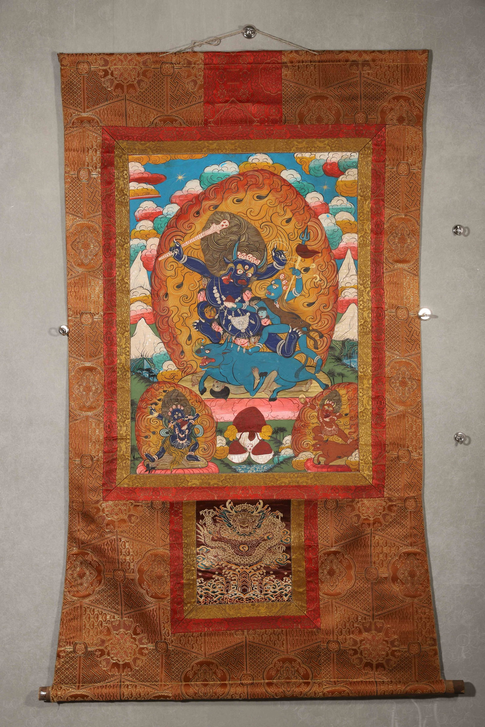 TIBETAN BUDDHIST THANGKA OF YAMA WITH CINNABAR HANDPRINTS, 19TH CENTURY: 28.74in x 20.47in (73.0cm x 52.0cm)This 19th-century Tibetan Thangka depicts Yama, the Lord of Death, in vivid mineral pigments and gilded flame details. Cinnabar handprints on the reverse confirm sac