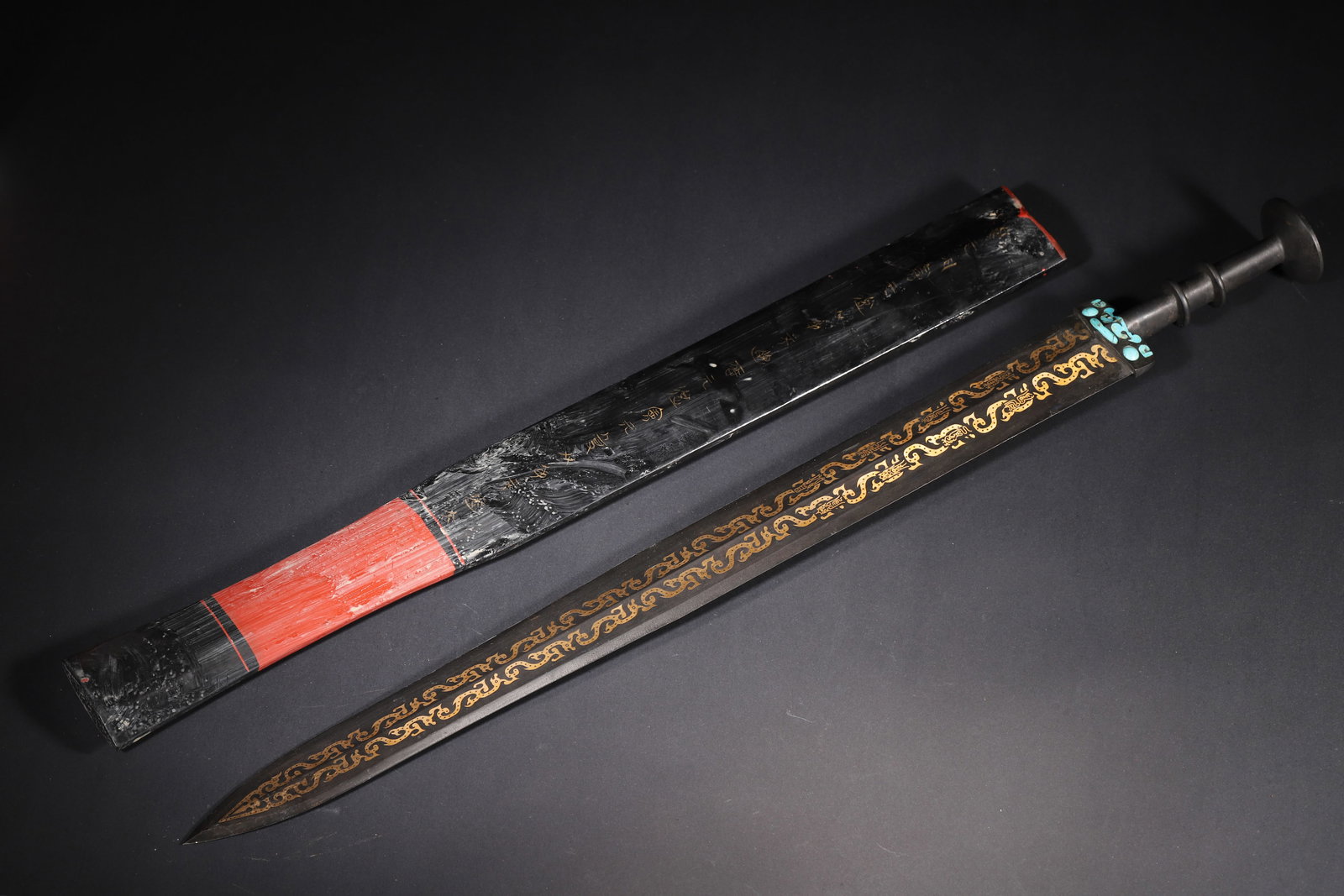 A FINE WARRING STATES PERIOD GOLD-INLAID BRONZE ORNAMENT WITH TURQUOISE INLAY AND LACQUER SCABBARD: 24.8in x 2.36in (63.0cm x 6.0cm), 2.315lb (1050.0g)This Warring States bronze ornament features intricate gold-inlaid kui-dragon patterns and turquoise inlay, paired with an original lacquer scabbard