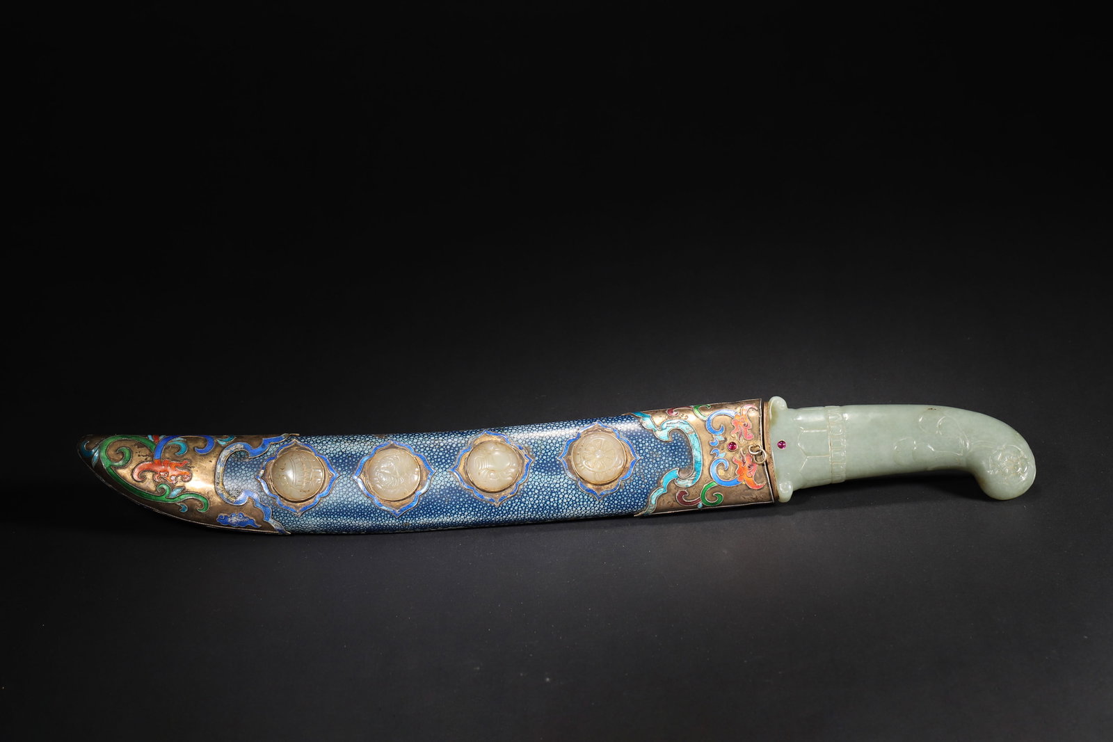 A FINE IMPERIAL CELADON JADE-HILTED DAGGER WITH ENAMEL AND JADE INLAY SCABBARD, QIANLONG PERIOD,: 18.11in x 1.97in (46.0cm x 5.0cm), 1.764lb (800.0g)This imperial dagger, crafted in the Qianlong period, features a celadon jade hilt and a scabbard adorned with enamel and eight Buddhist treasures ja