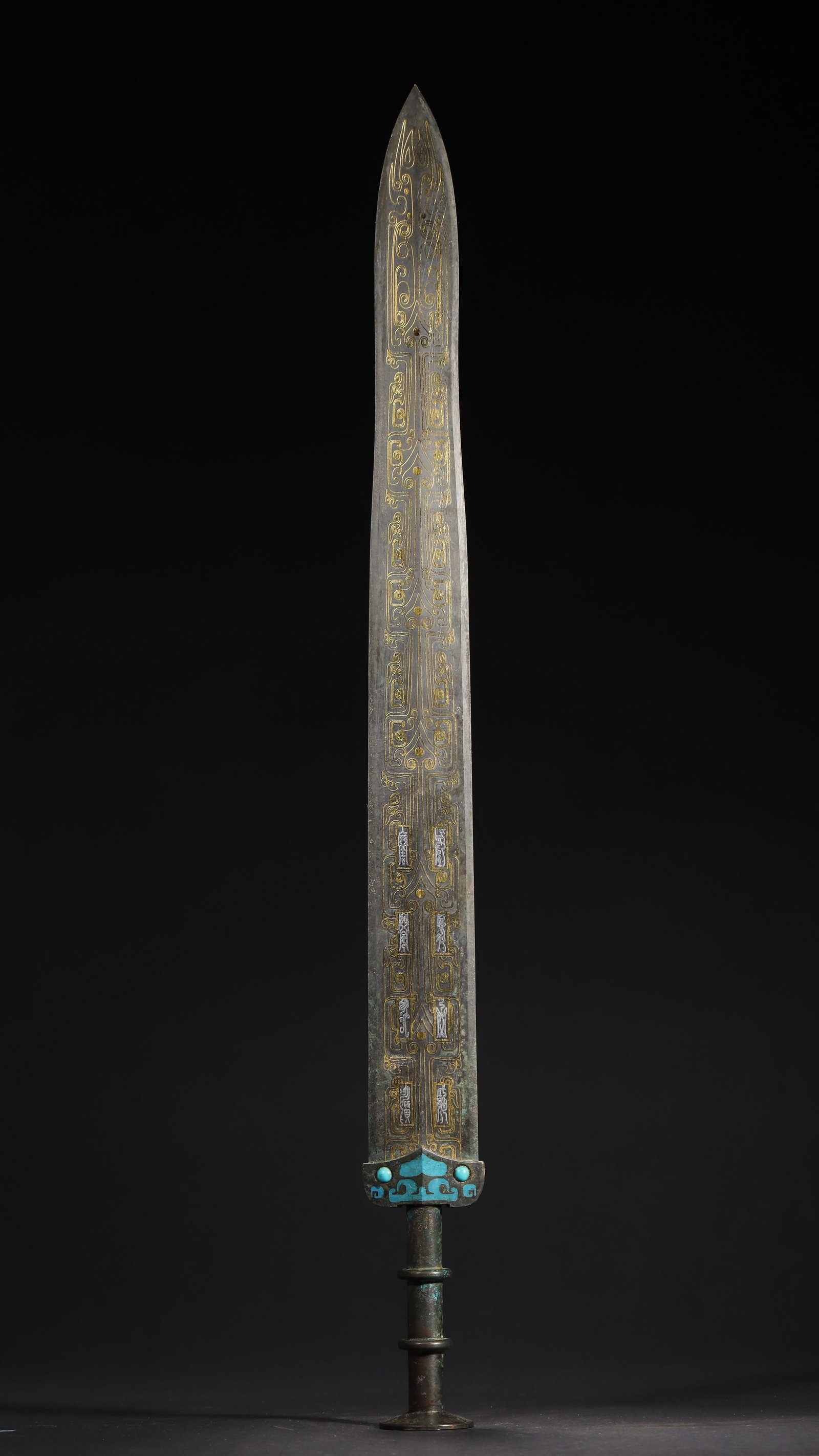 WARRING STATES TO HAN DYNASTY BRONZE ORNAMENT WITH GOLD AND SILVER INLAID KUI DRAGON PATTERNS AND: 24.02in x 2.2in (61.0cm x 5.6cm), 2.088lb (947.0g)A fine Warring States to Han Dynasty bronze ornament with gold/silver inlaid kui dragon patterns, turquoise inlay, and concentric pommel. Exemplifying