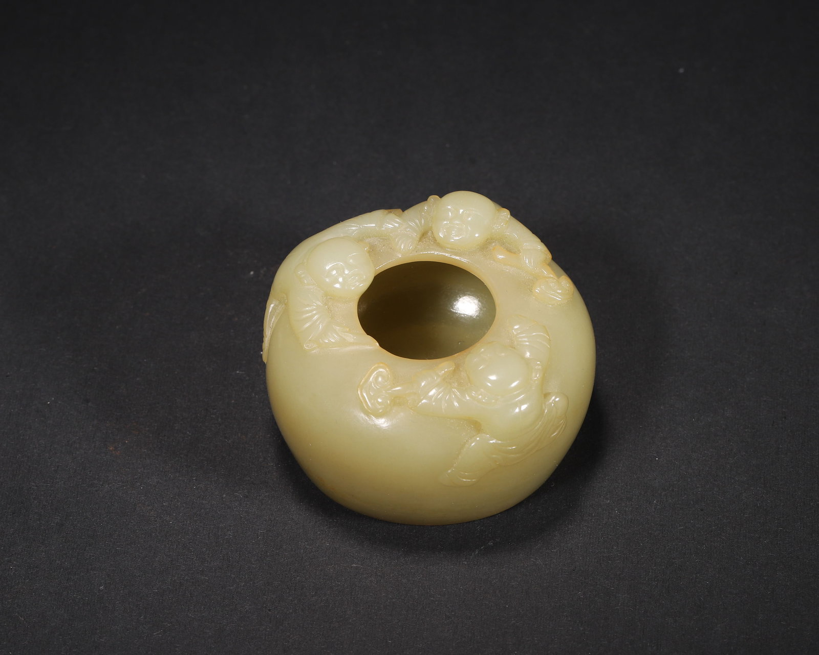 A FINE HETIAN YELLOW JADE WATER POT WITH CHILDREN AT PLAY MOTIF, MID-QING DYNASTY: 1.97in x 1.18in (5.0cm x 3.0cm), 0.207lb (94.0g)This elegant Mid-Qing Hetian yellow jade water pot features a robust form and high-relief children at play carvings. With natural golden skin inclusions