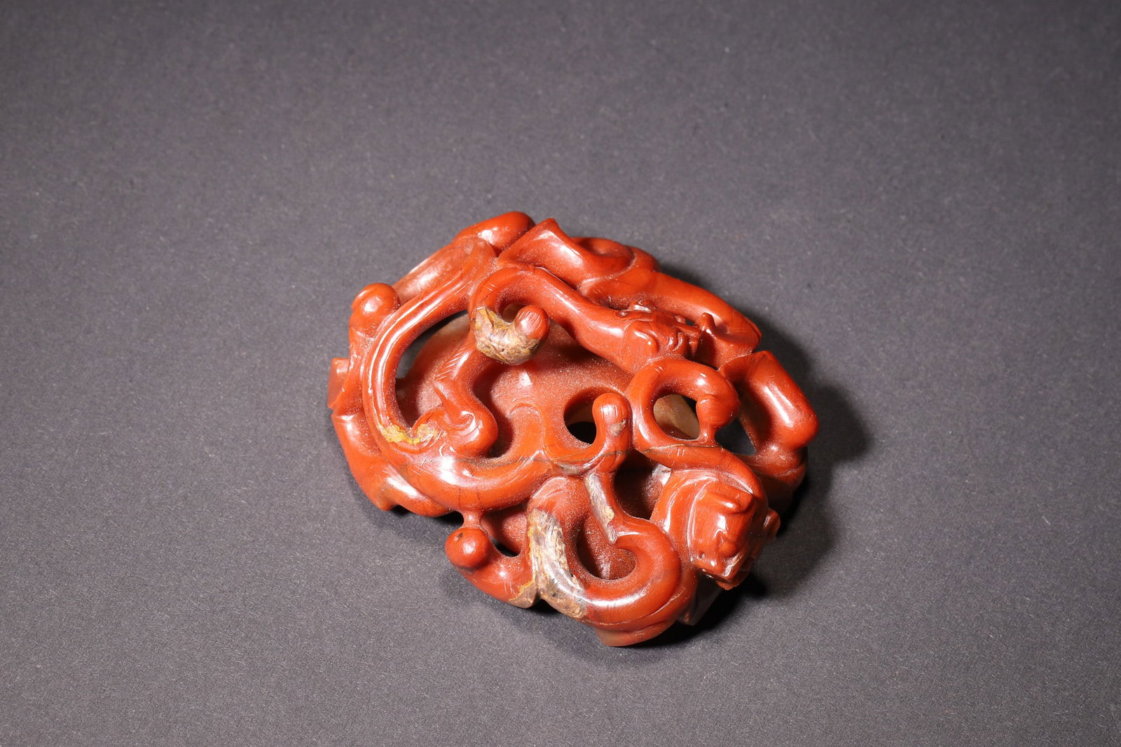 A Han Dynasty Southern Red Agate Heart-Shaped Pendant with Openwork Chilong Pattern: Length 6.8cm (2.68in), Width 5.5cm (2.17in), Weight 70.0g (0.15lb)A Han Dynasty southern red agate heart-shaped pendant, carved with openwork chilong patterns. The vivid red color and exquisite crafts