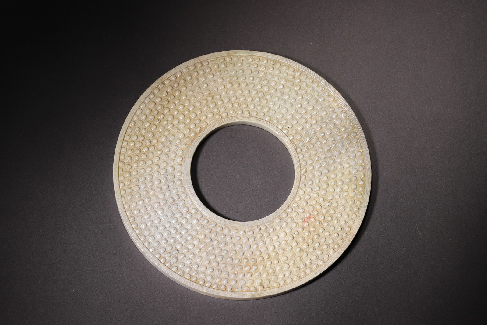 A Hetian Jade Grain Pattern Bi Disc - Han Dynasty: Diameter 17.0cm (6.69in), Weight 338.0g (0.75lb)This Han Dynasty jade bi is finely carved from Hetian jade with natural aged patina. It features full-grain patterns with plump and neatly arranged grai