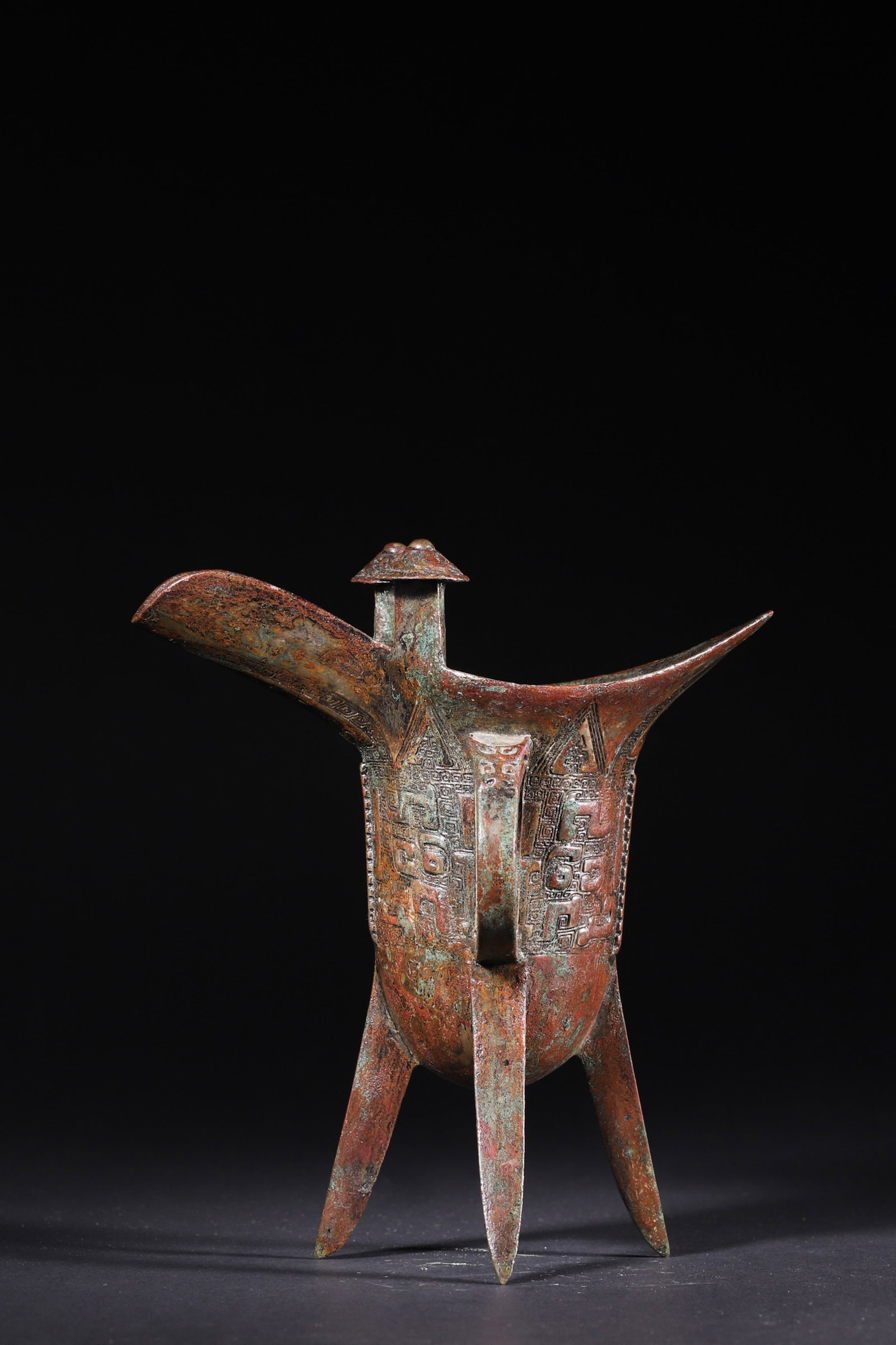 A Bronze Jue Cup with Beast-Face Motifs - Late Shang Dynasty: Length 17.0cm (6.69in), Width 11.0cm (4.33in), Height 19.0cm (7.48in), Weight 719.0g (1.59lb)This bronze jue cup is a classic ritual wine vessel of the Late Shang Dynasty, with elegant shape, beast-he