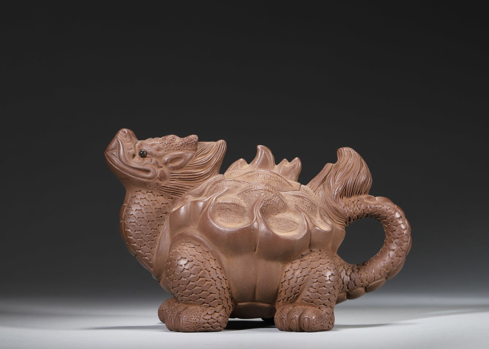 Kangxi Period, Qing Dynasty A Yixing Zisha Dragon-Turtle Teapot, Mark of Chen Mingyuan: 17.0 x 10.0 x 11.0 cm (6.69 x 3.94 x 4.33 in)Crafted in the Kangxi period by master Chen Mingyuan, this Yixing teapot is superbly potted in the form of a dragon-turtle. The body is well-proportioned, 