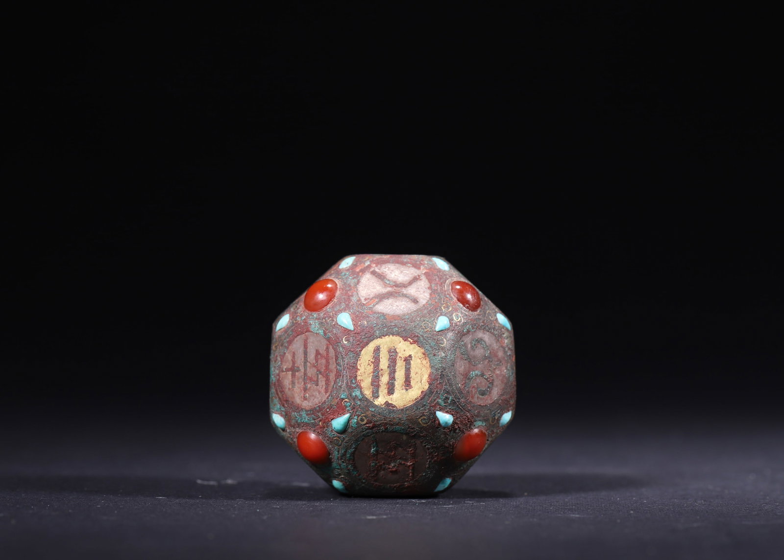 A Bronze Liubo Dice with Gold/Silver Inlay and Turquoise/Agate Inlays, Han Dynasty: Diameter 4.3cm (1.69in), Weight 82.0g (0.18lb)This Han Dynasty wine-order dice is cast in bronze, adorned with gold and silver inlay and set with turquoise and agate. Its multi-faceted surfaces bear i