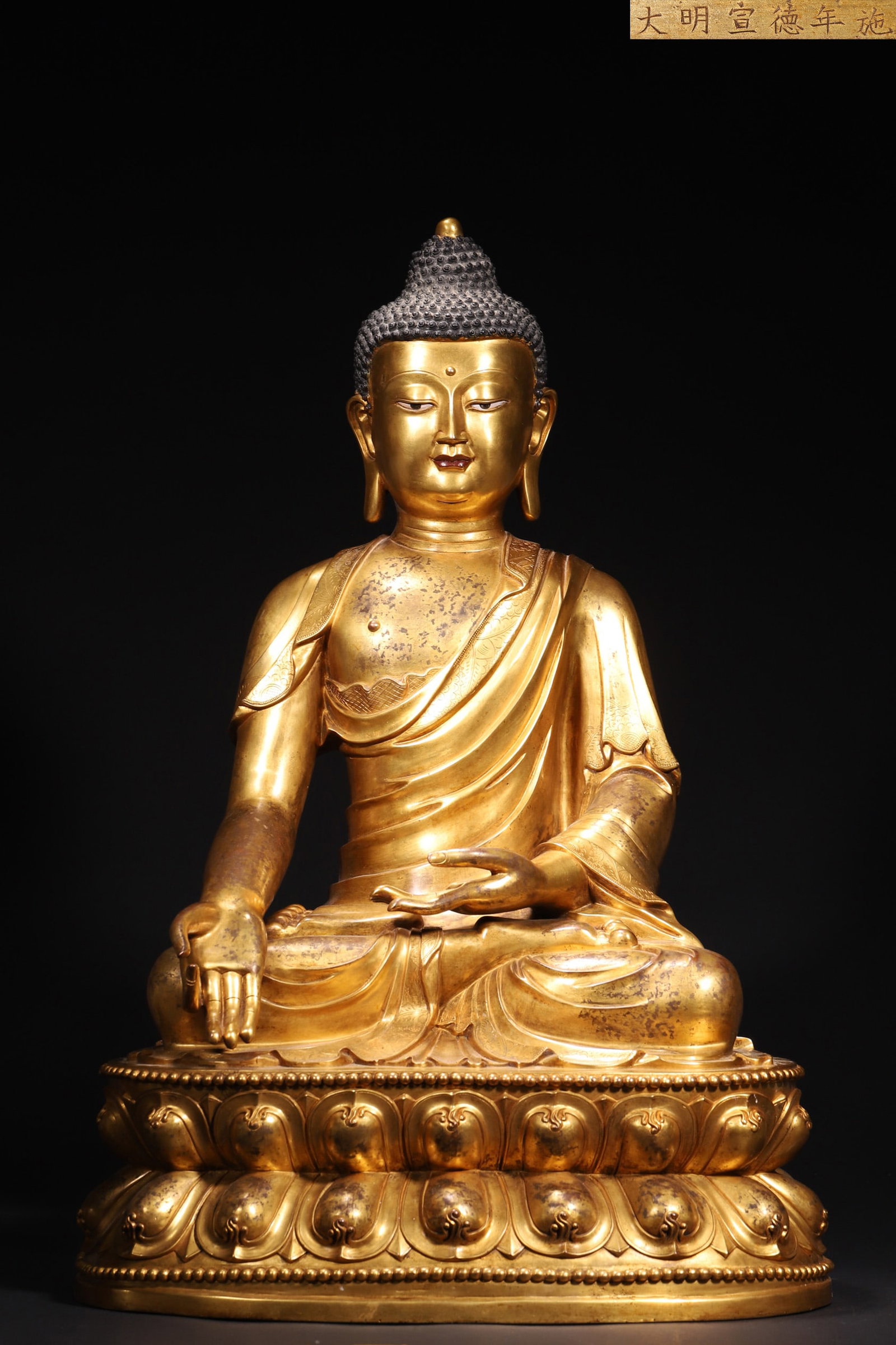 A Gilt-Bronze Seated Statue of Shakyamuni Buddha, Imperial Made, Xuande Period, Ming Dynasty: Length 41.0cm (16.14in), Width 31.0cm (12.2in), Height 61.0cm (24.02in), Weight 23.3kg (51.37lb)This is an imperial-made gilt-bronze seated statue of Shakyamuni Buddha crafted in the Xuande Period of 