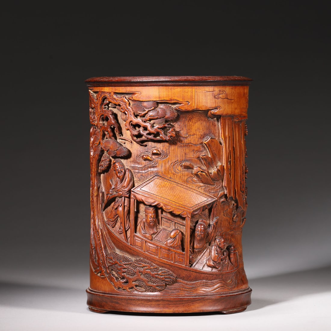 A Bamboo Carved Brush Pot with "Night Tour at Red Cliff?? Scene, Qing Dynasty: D 11.6cm (4.57 in); H 15.9cm (6.26 in); Wt 398g (0.88 lb)A bamboo brush pot carved with "Night Tour at Red Cliff" scene in deep relief, featuring vividly depicted figures, boats, pines and cliffs with