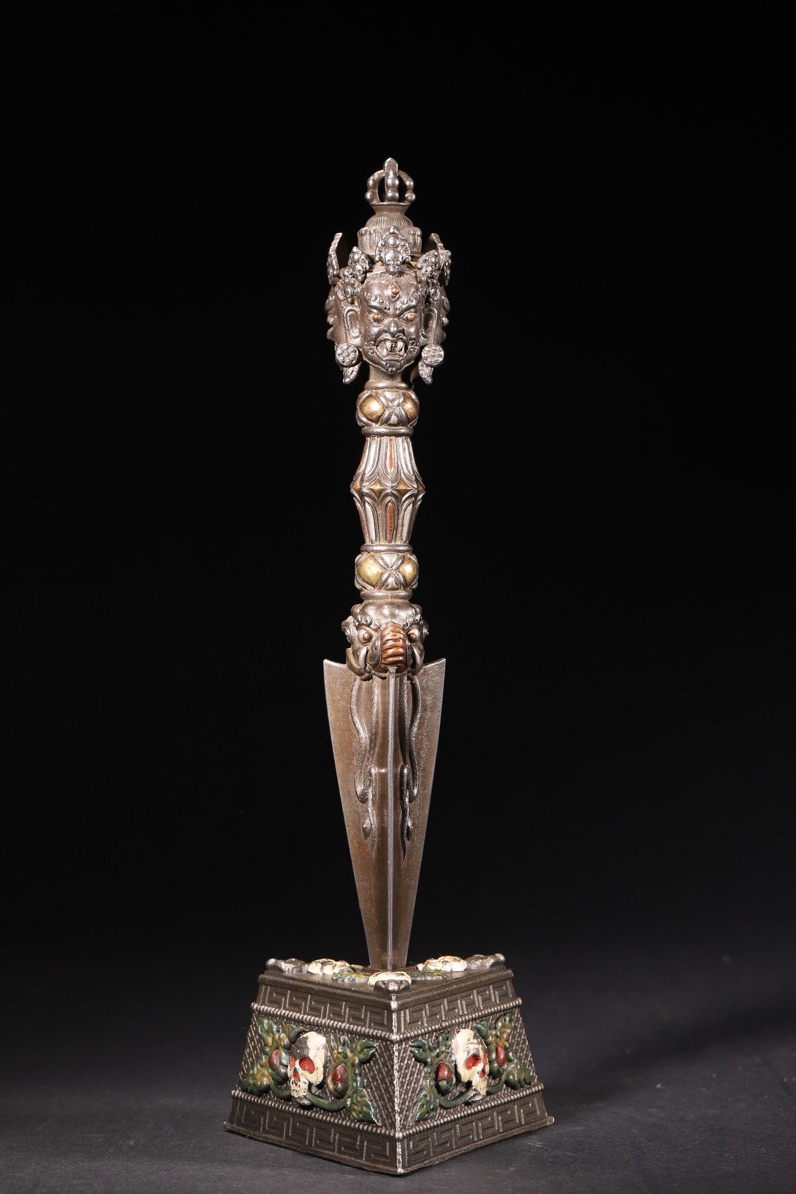 A Qing Dynasty Copper Phurba (Kila): Width 8.5cm (3.35in), Height 25.5cm (10.04in), Weight 845.0g (1.86lb)This Qing Dynasty copper Phurba (Kila) is a Tibetan Buddhist ritual implement, partially gilded and painted. The top features a thr