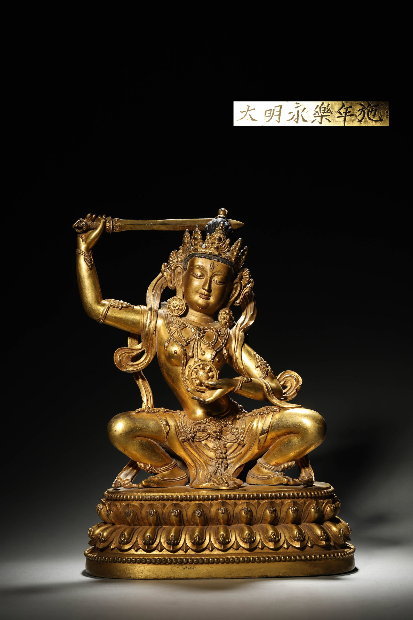 An Imperial Gilt-Bronze Statue of Squatting Vairocana Buddha, Ming Dynasty, Yongle Period: L 23cm (9.06 in); W 12cm (4.72 in); H 34cm (13.39 in); Wt 5.79kg (12.76 lb)An imperial gilt-bronze Vairocana Buddha statue, Ming Dynasty Yongle Period, in a squatting pose. Inscribed with "???????" ma