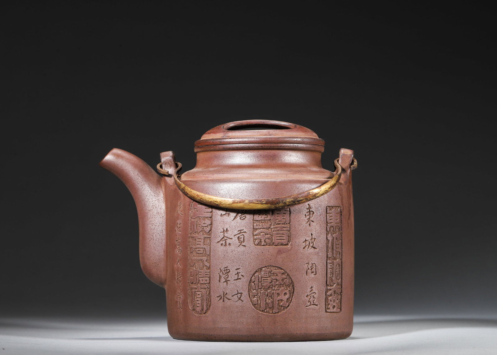 Gu Jingzhou Made Yixing Cooperative Purple Sand "Yangtong" Teapot with Carved Poetry & Landscape: 15.0 x 10.0 x 13.0 cm (5.91 x 3.94 x 5.12 in)This is a classic Yangtong teapot made by Gu Jingzhou, the master of Zisha, during Yixing Cooperative period. Crafted from raw ore purple sand with a brass