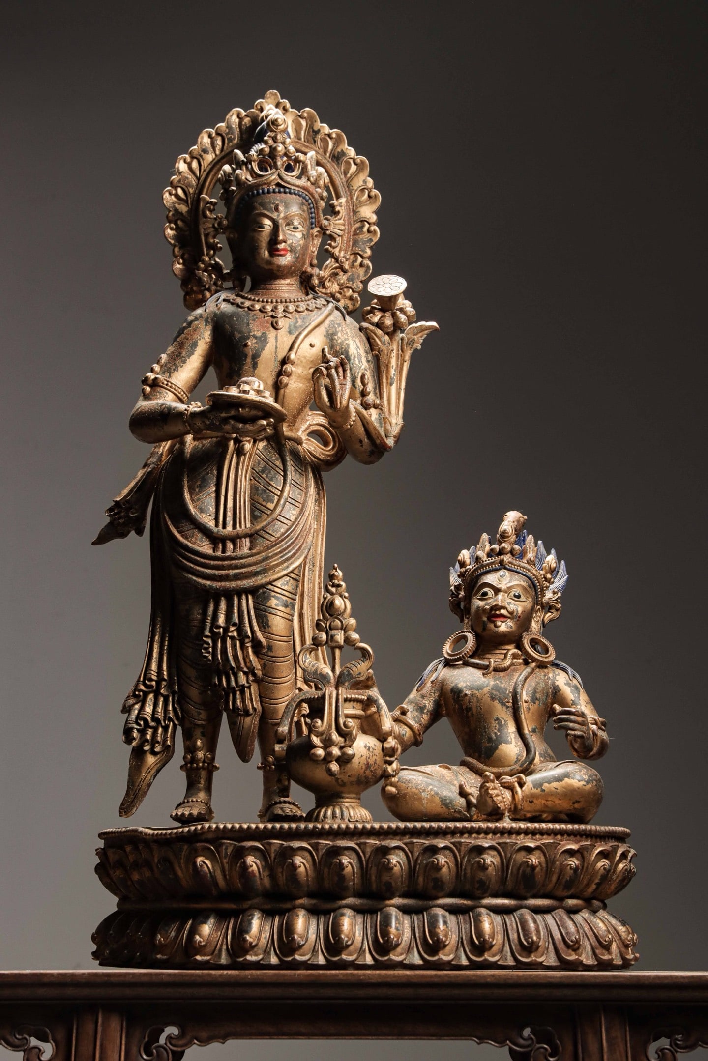 A Gilt Copper Group of Padmapani Bodhisattva with Mahasiddha, Qing Dynasty: Weight 89jin (98.11 lb); Height 100cm (39.37 in); Width 58cm (22.83 in); Thickness 29.5cm (11.61 in)A gilt copper group of Padmapani Bodhisattva with Mahasiddha from the Qing Dynasty, featuring a sere